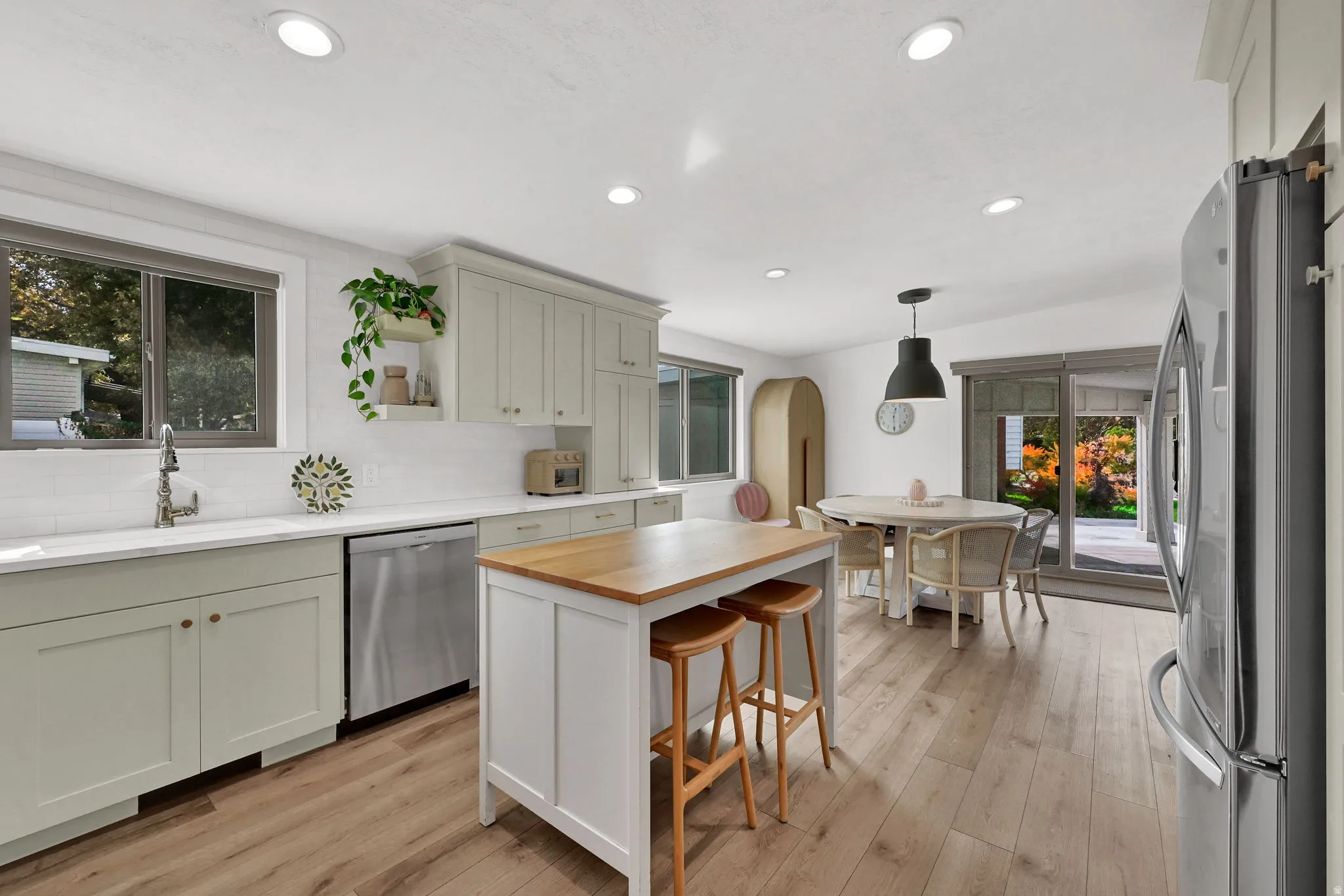 Kitchen featuring stainless steel appliances, a kitchen breakfast bar, wood counters, pendant lighting, and arched walkways