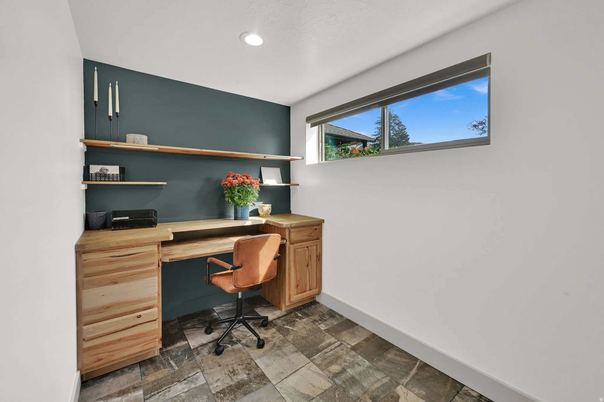 Office area with stone tile flooring and built in desk