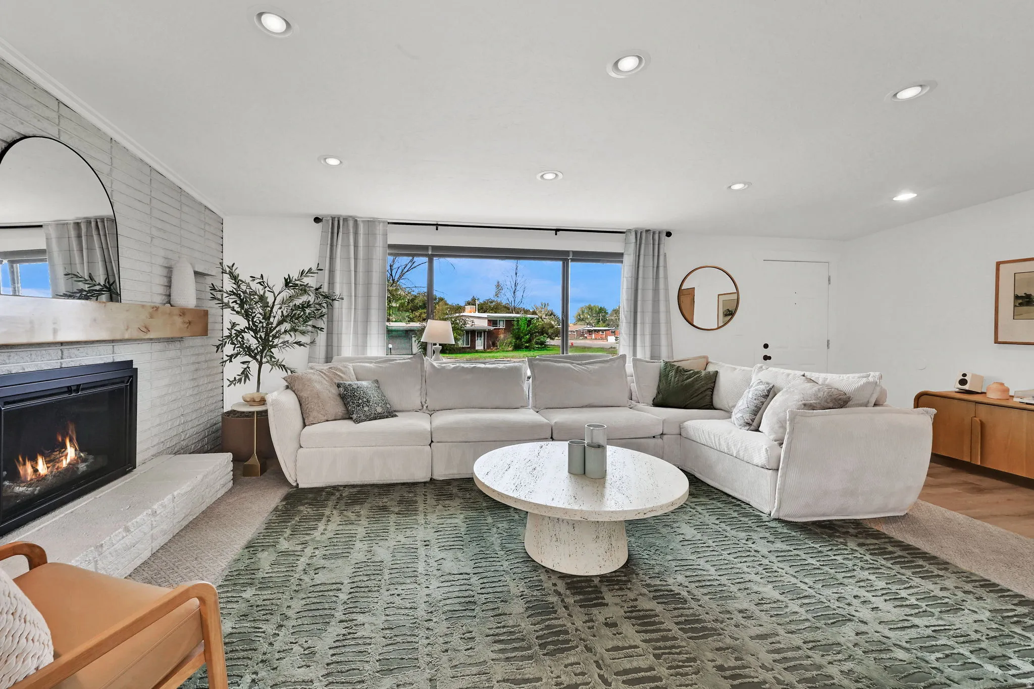 Living area with recessed lighting and a brick fireplace