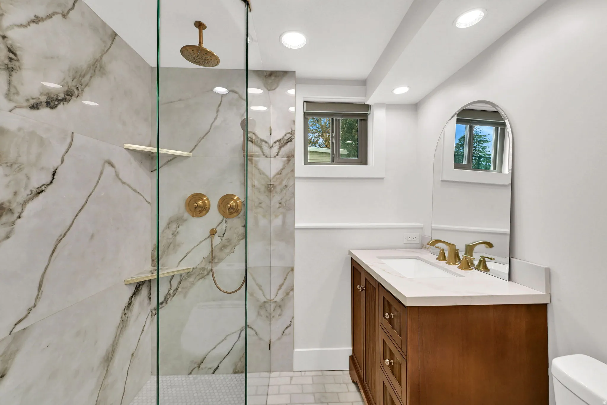 Full bath featuring vanity, a marble finish shower, and recessed lighting