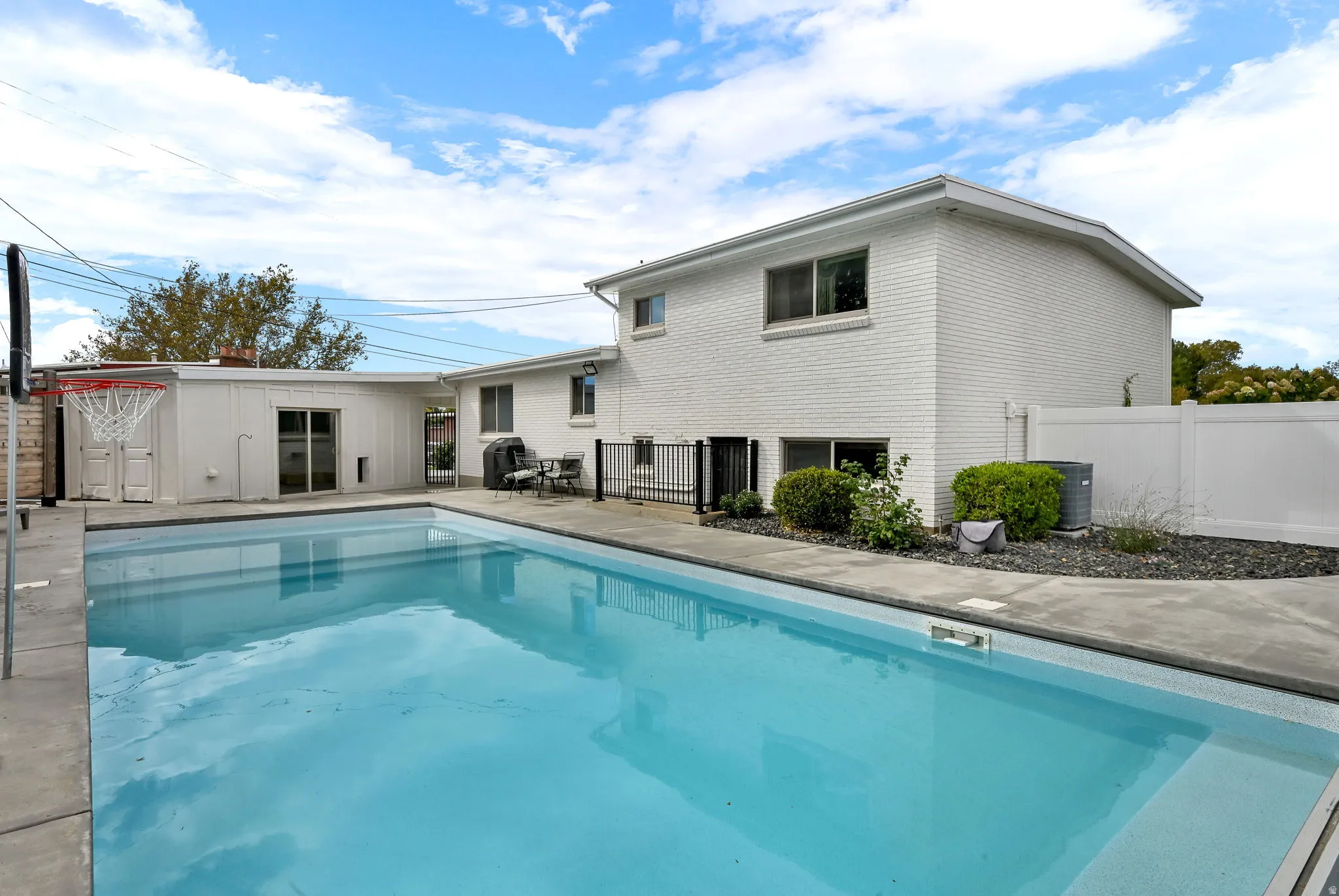 View of swimming pool with a patio and an outdoor structure