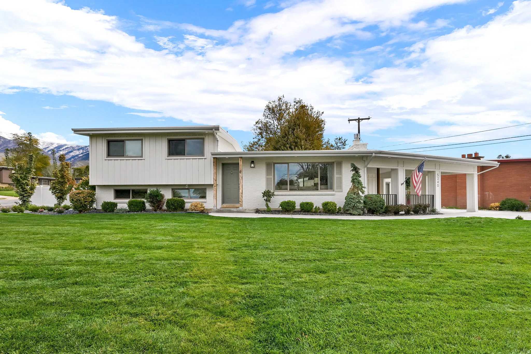 View of front facade featuring a front yard, concrete driveway, and a garage