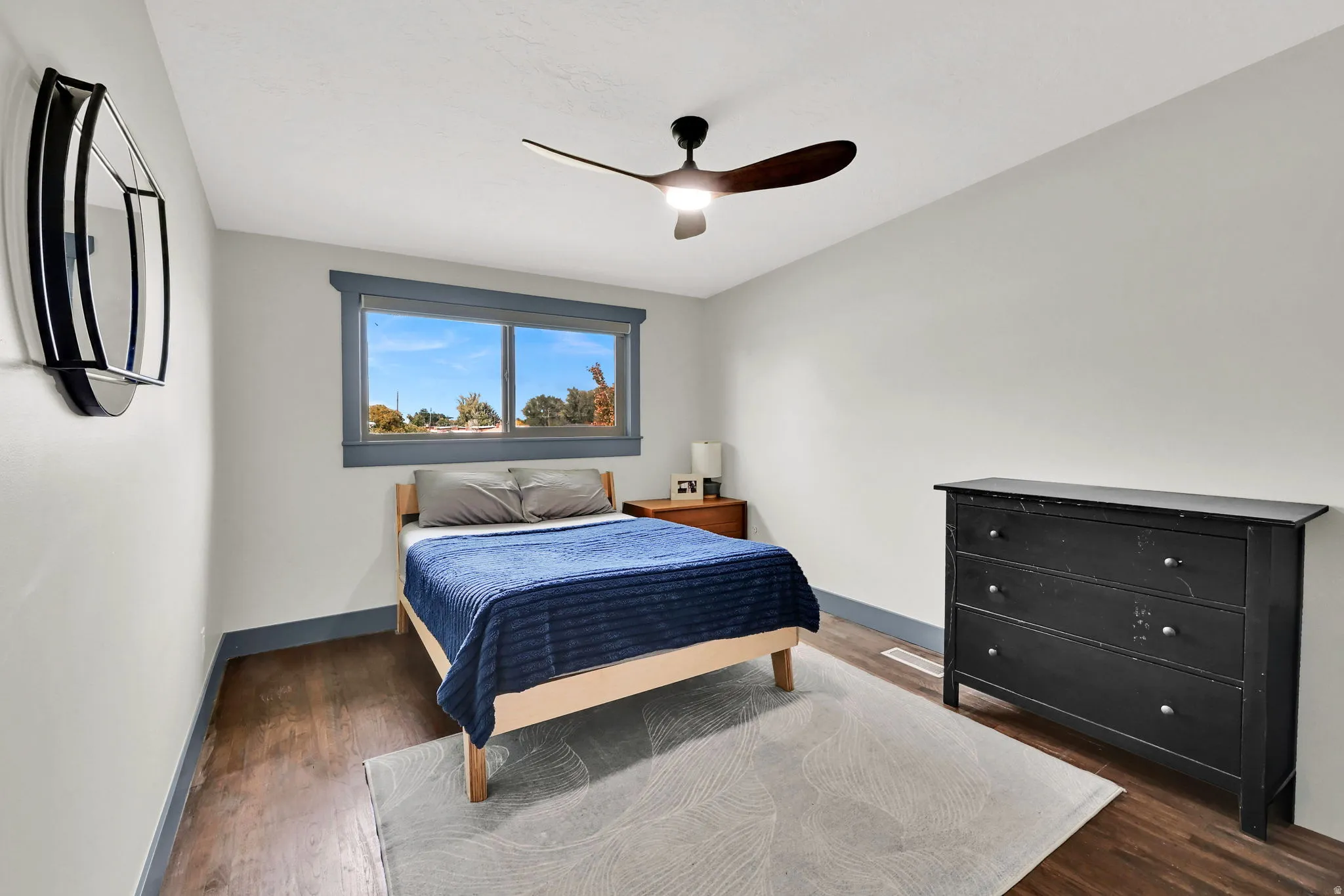 Bedroom with dark wood-style flooring and a ceiling fan