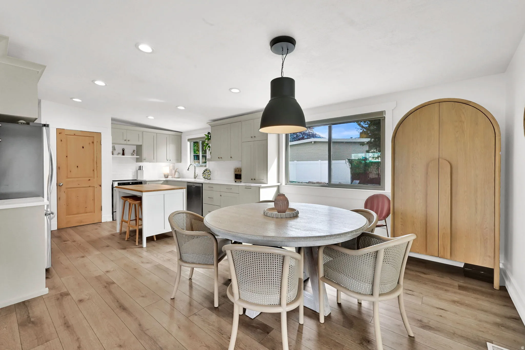 Dining room featuring light wood-style floors, recessed lighting, and arched walkways
