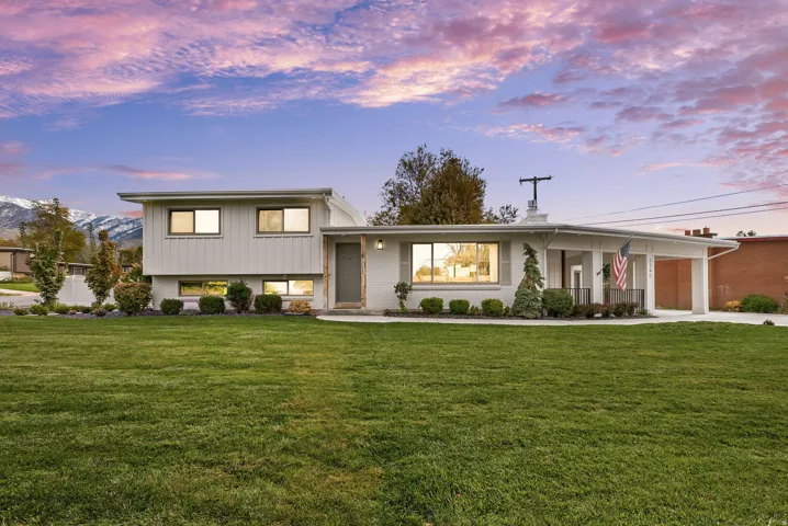 Split level home with concrete driveway, a yard, and an attached garage