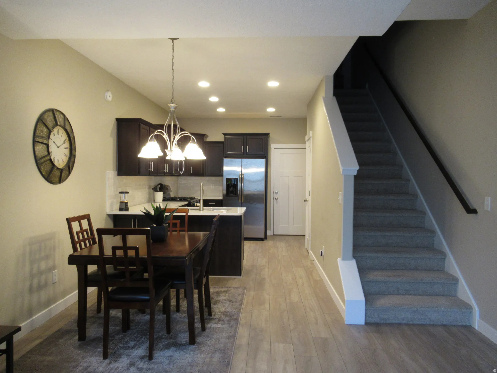 Dining space featuring hanging lights and dark wood-style flooring