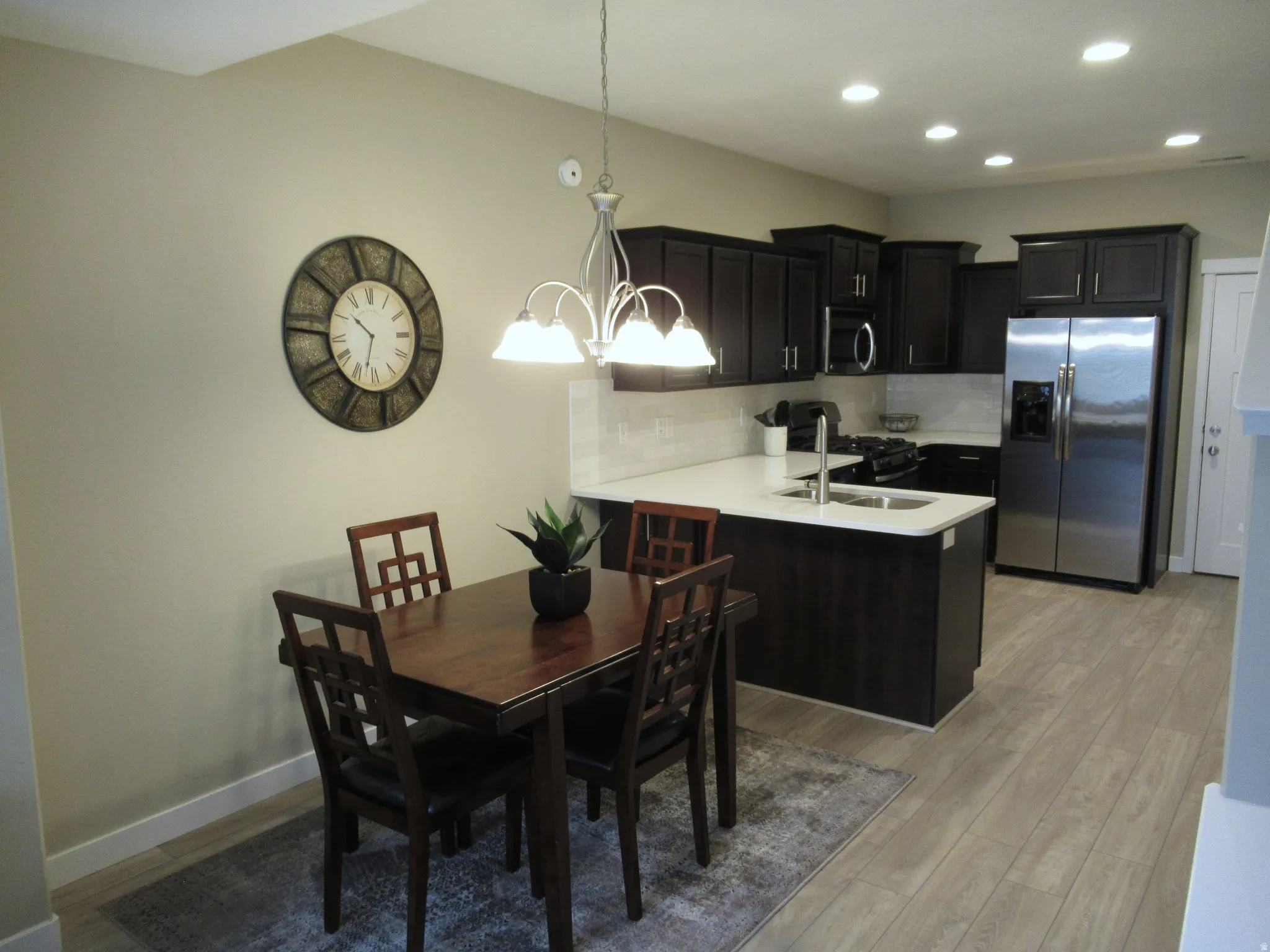 Dining space with suspended lighting and light wood finished floors