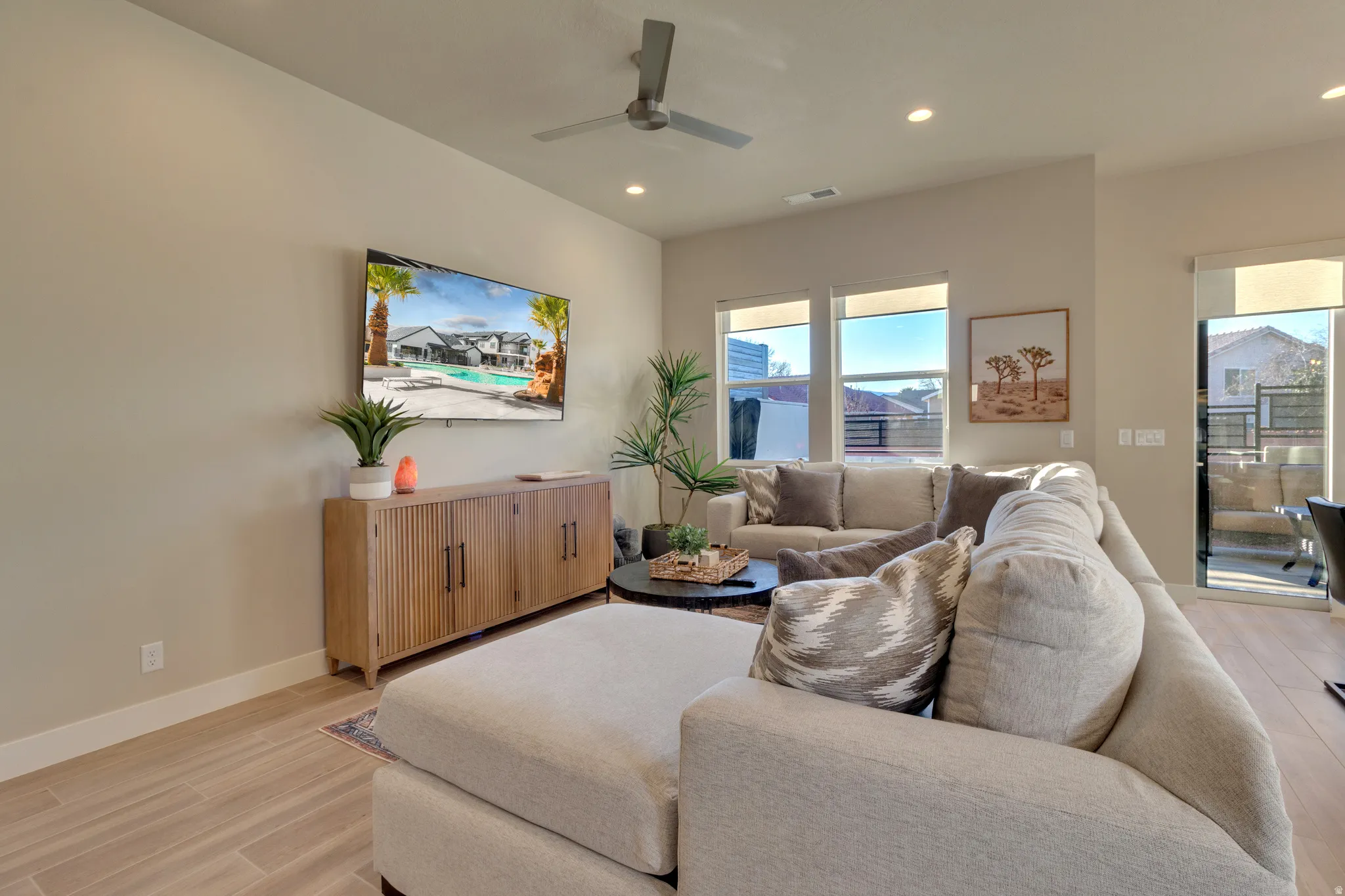 Living area with a ceiling fan, recessed lighting, and light wood-type flooring
