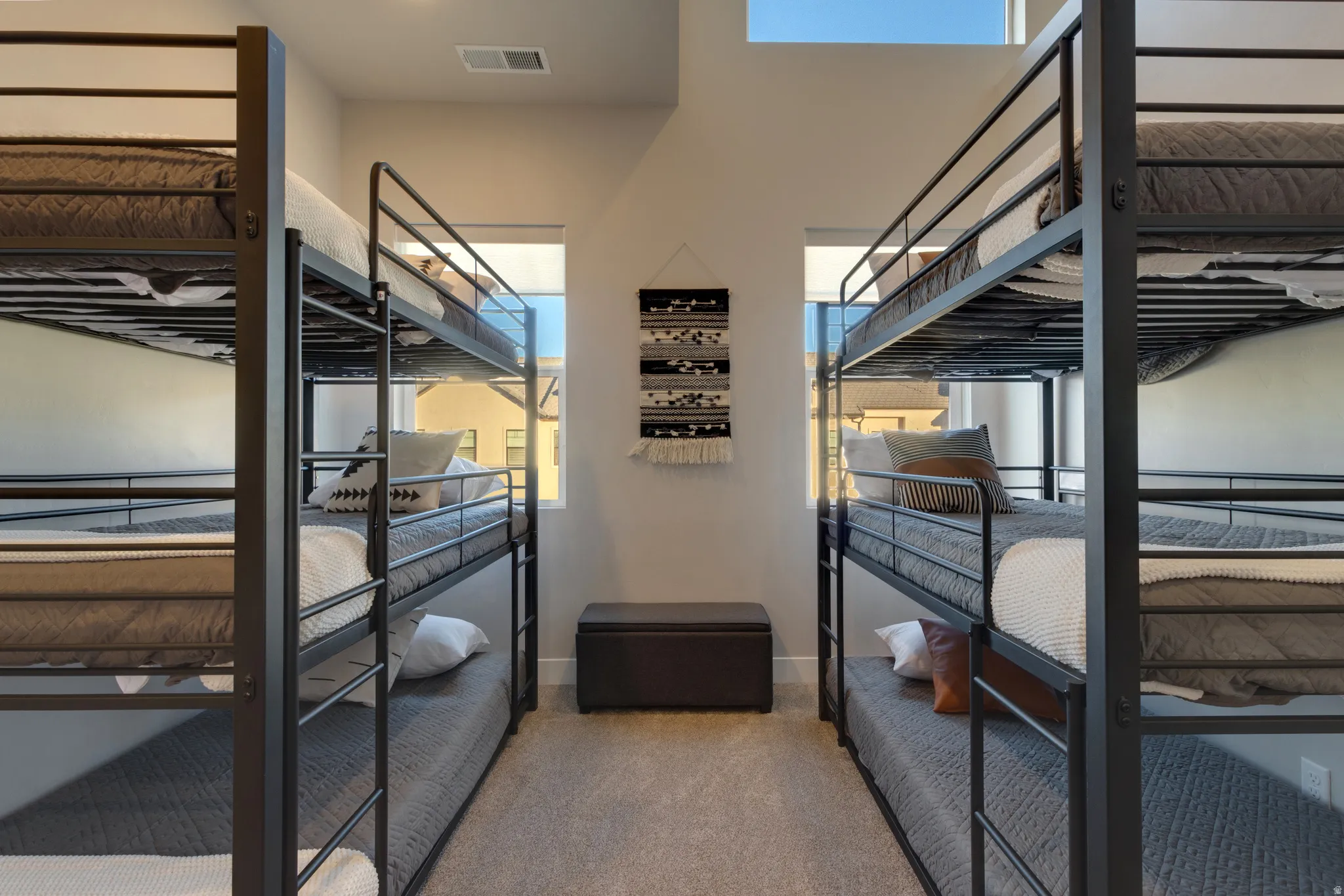 Bedroom featuring multiple windows and light carpet