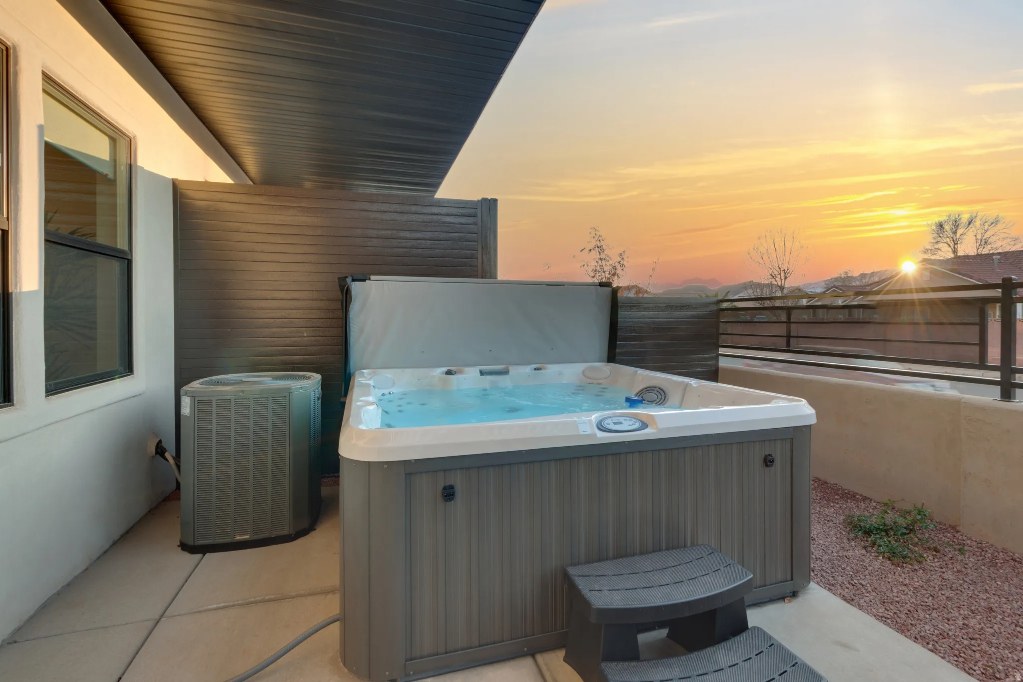 Patio terrace at dusk featuring a hot tub and a patio