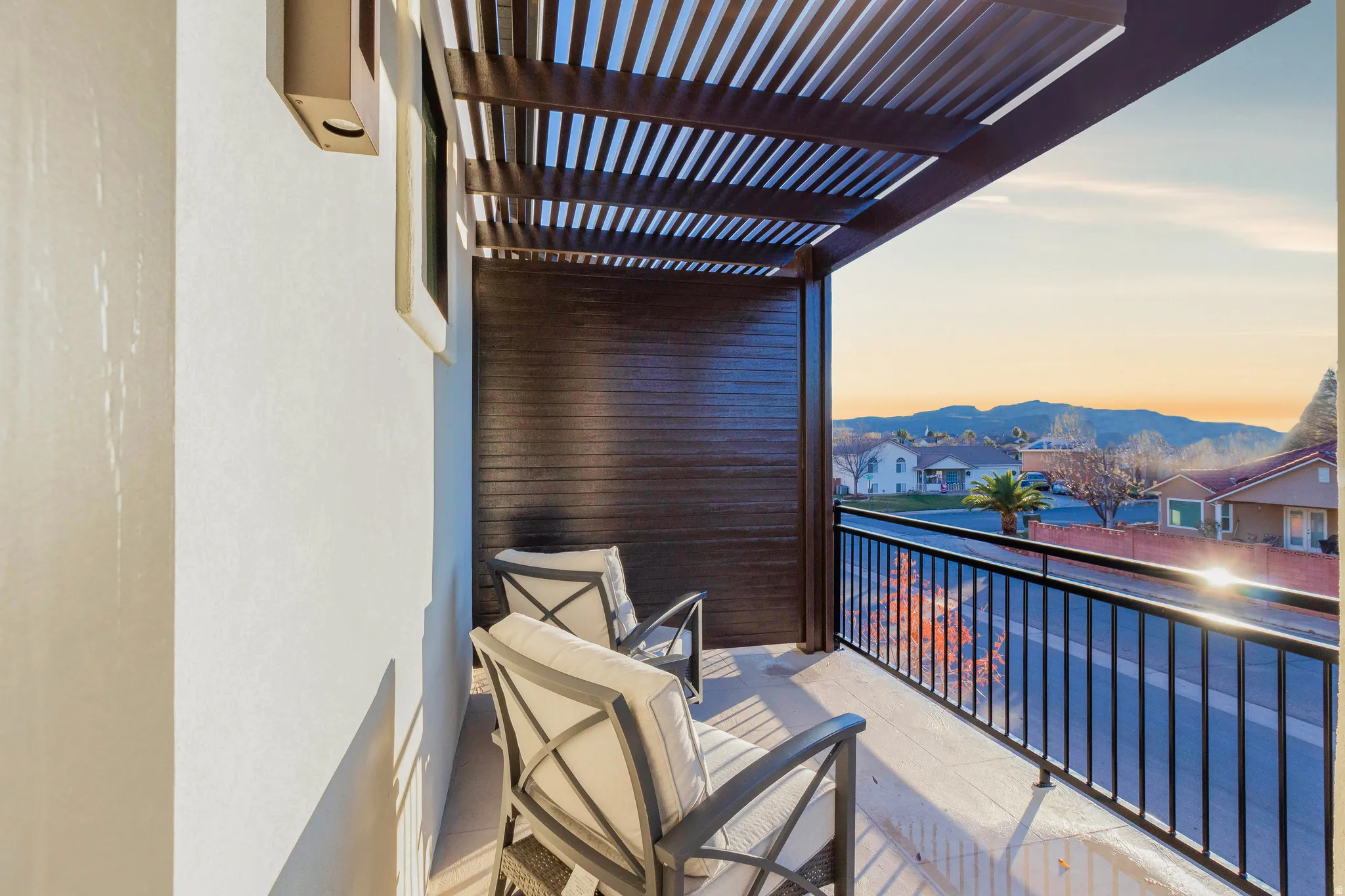 Balcony at dusk featuring a mountain view and a residential view