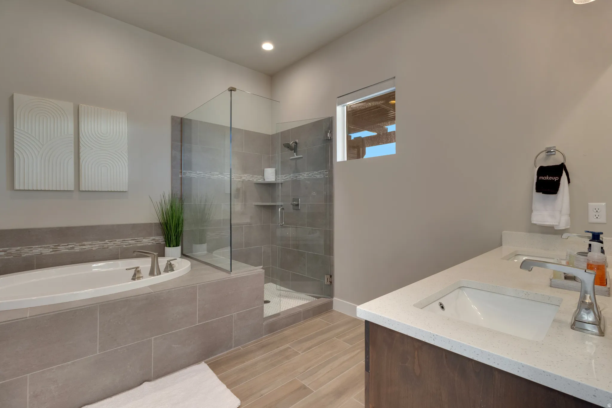 Full bathroom featuring double vanity, a garden tub, a shower stall, and wood tiled floors
