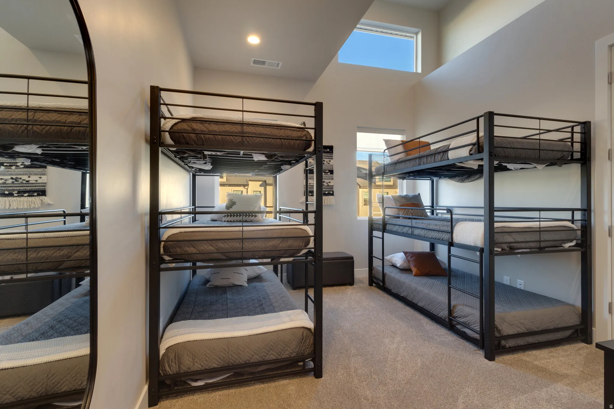 Bedroom with a high ceiling and light carpet