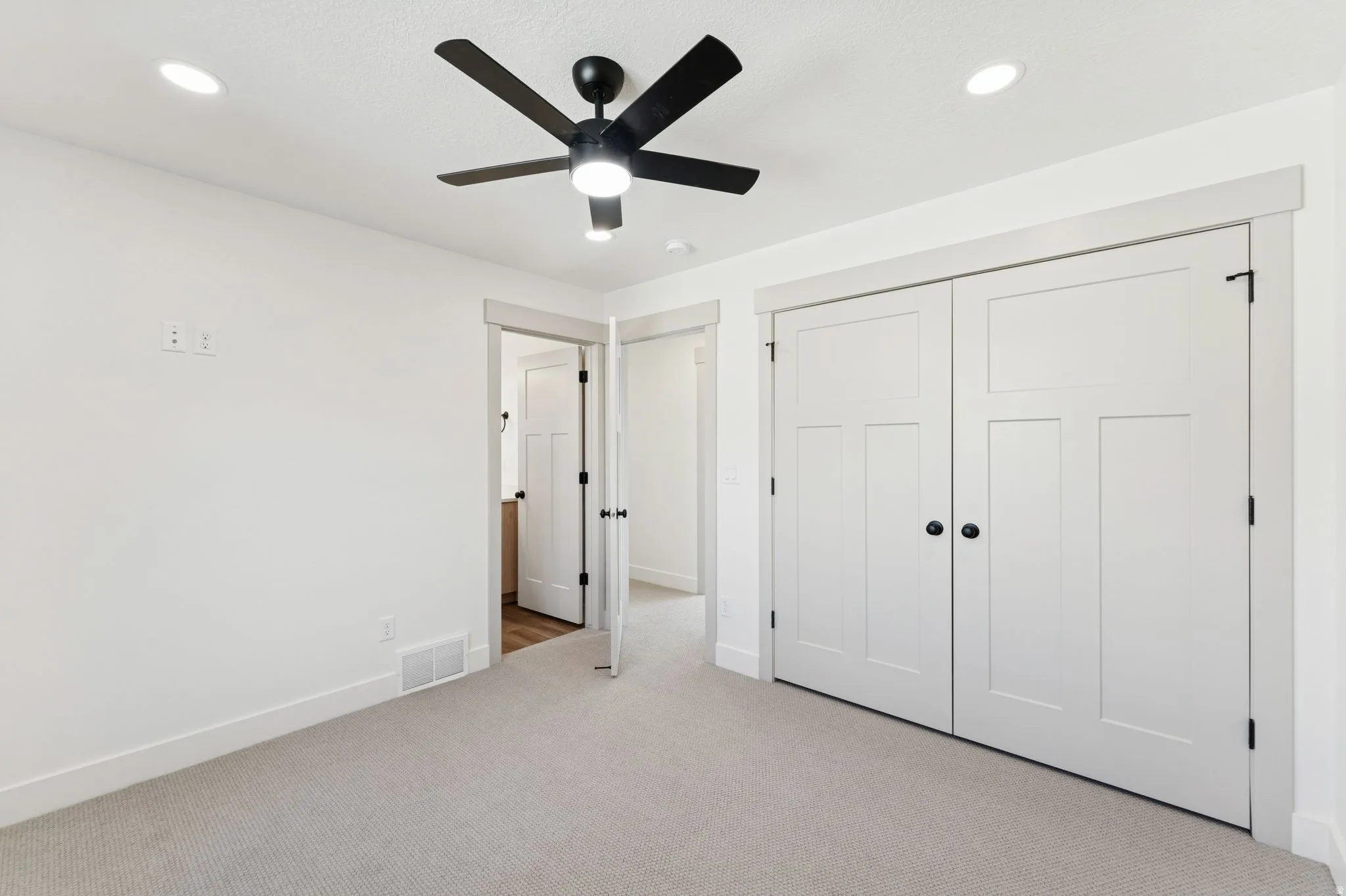 Unfurnished bedroom with light colored carpet, a closet, a ceiling fan, and recessed lighting