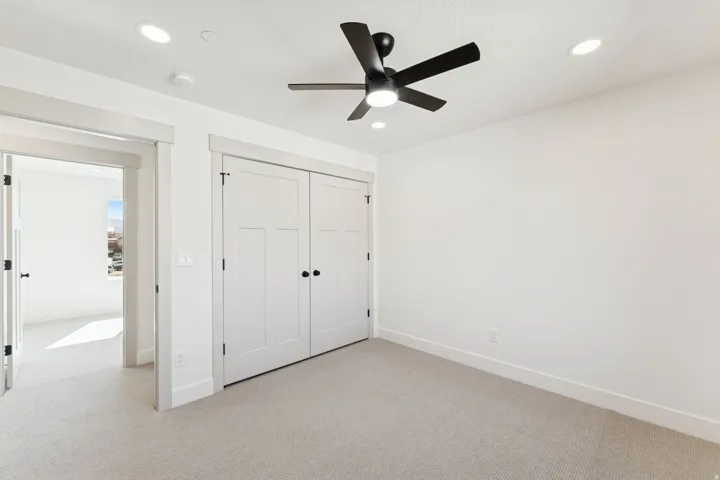 Unfurnished bedroom featuring light carpet, a closet, a ceiling fan, and recessed lighting