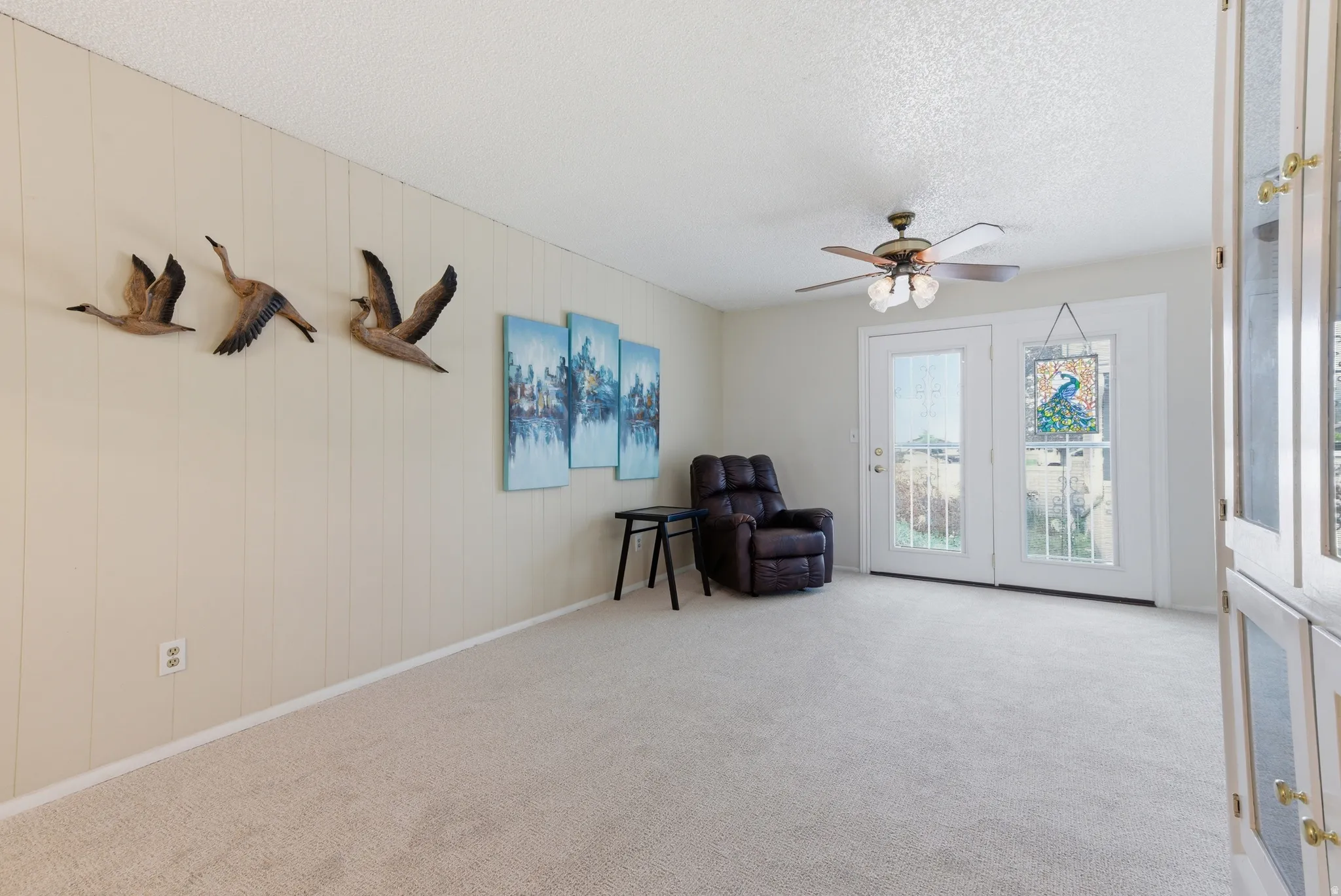 Sitting room with a ceiling fan, a textured ceiling, and carpet