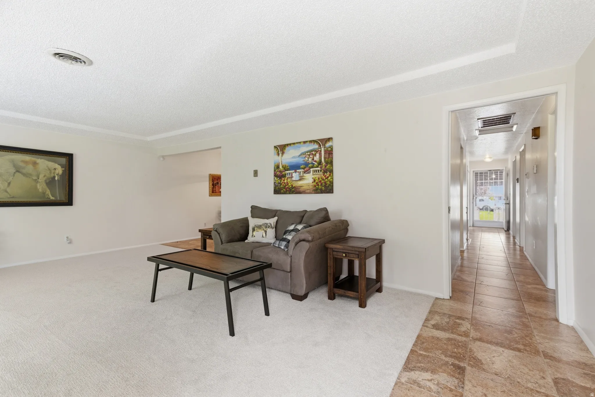 Living area featuring a textured ceiling and light colored carpet