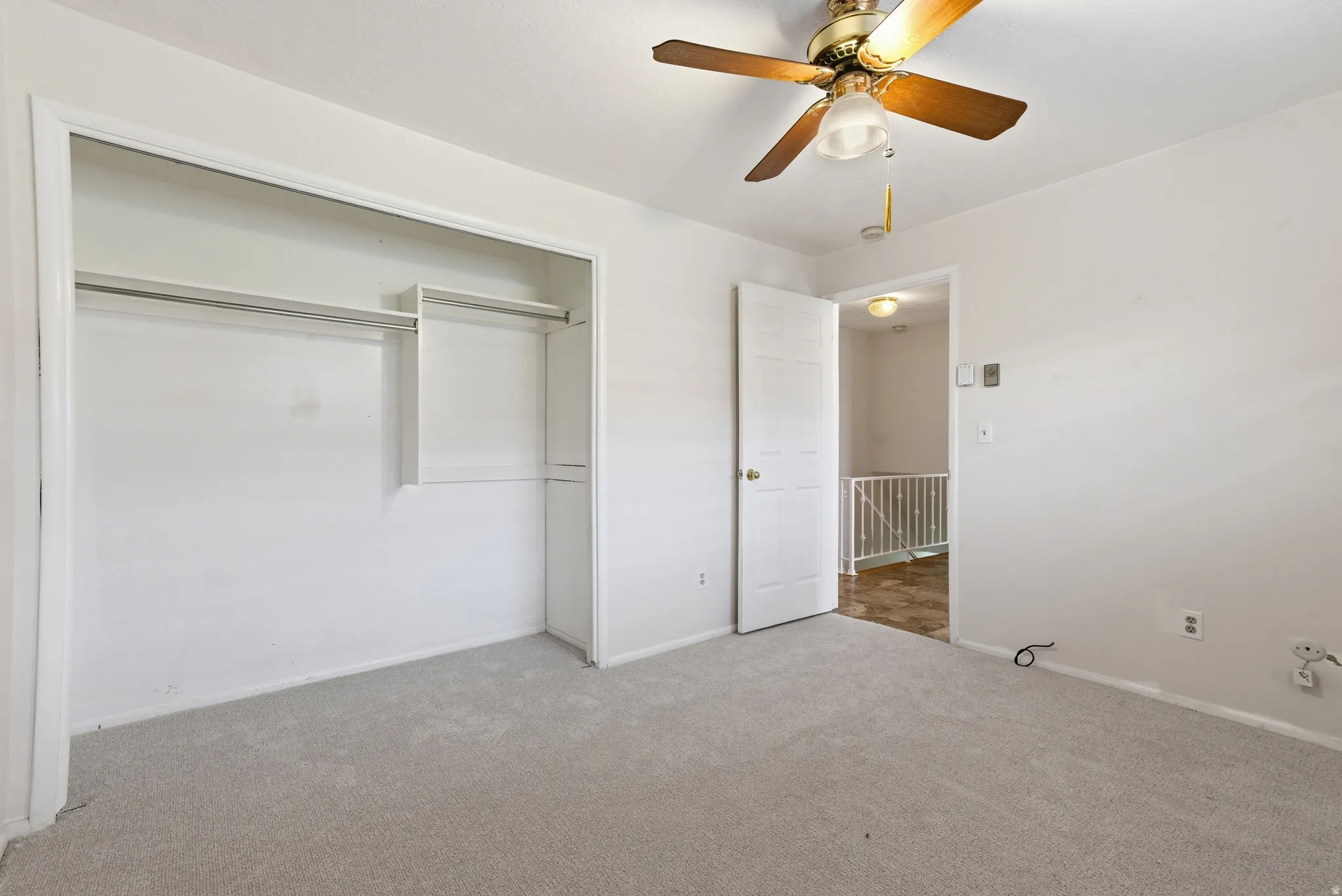 Unfurnished bedroom featuring carpet floors, ceiling fan, and a closet