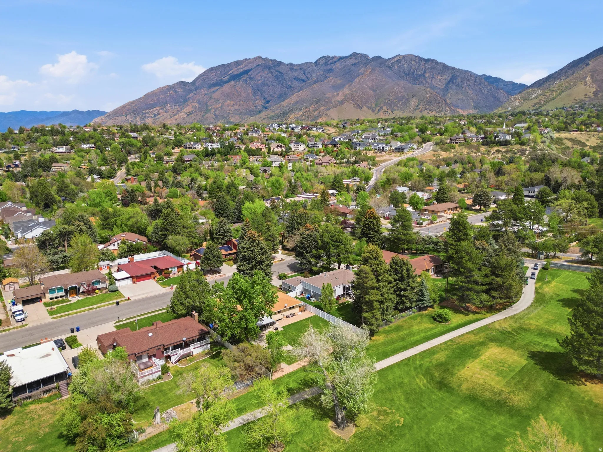 Aerial view of residential area featuring a golf course and mountain backdrop
