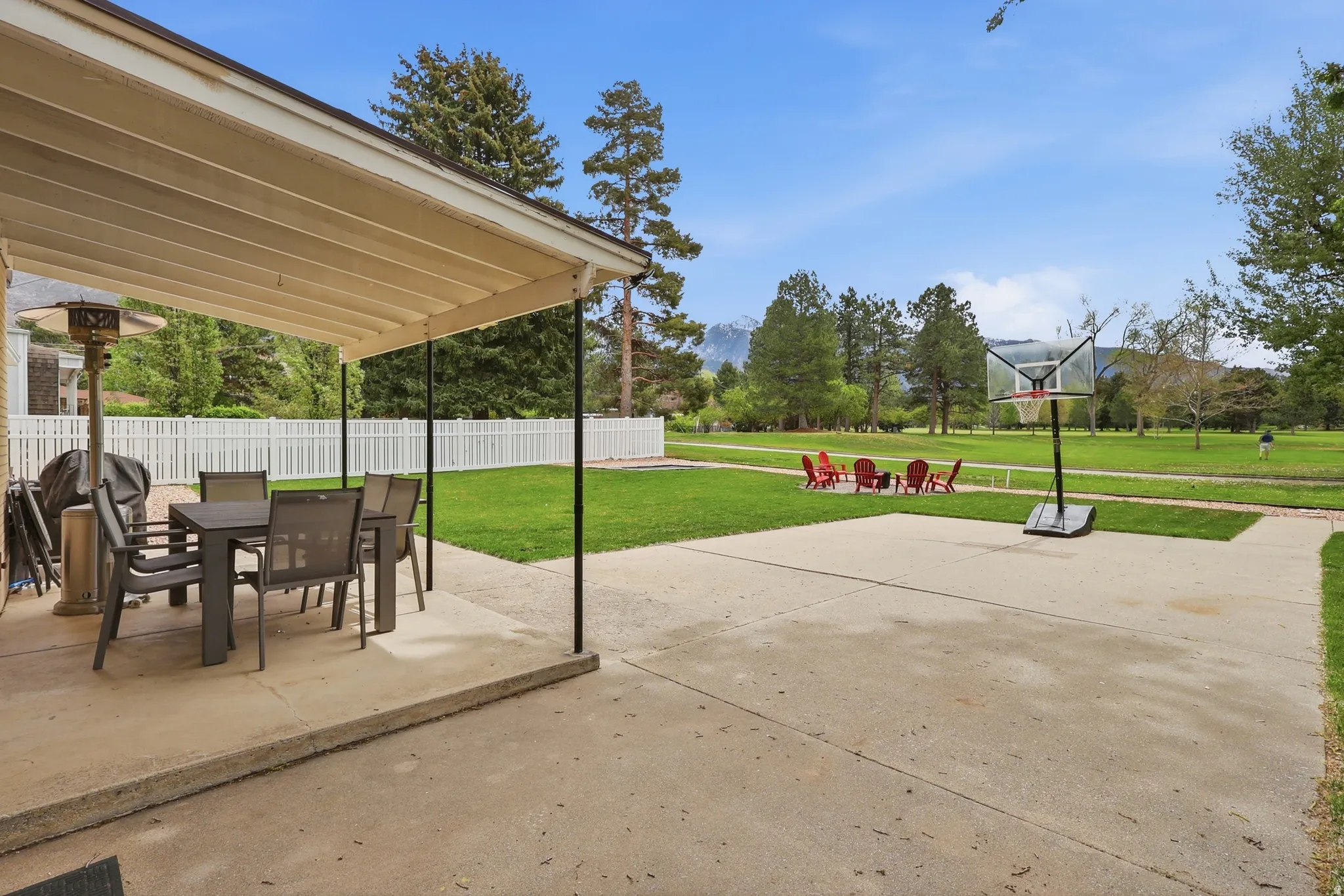 Covered patio with outdoor dining area featuring a golf course backdrop