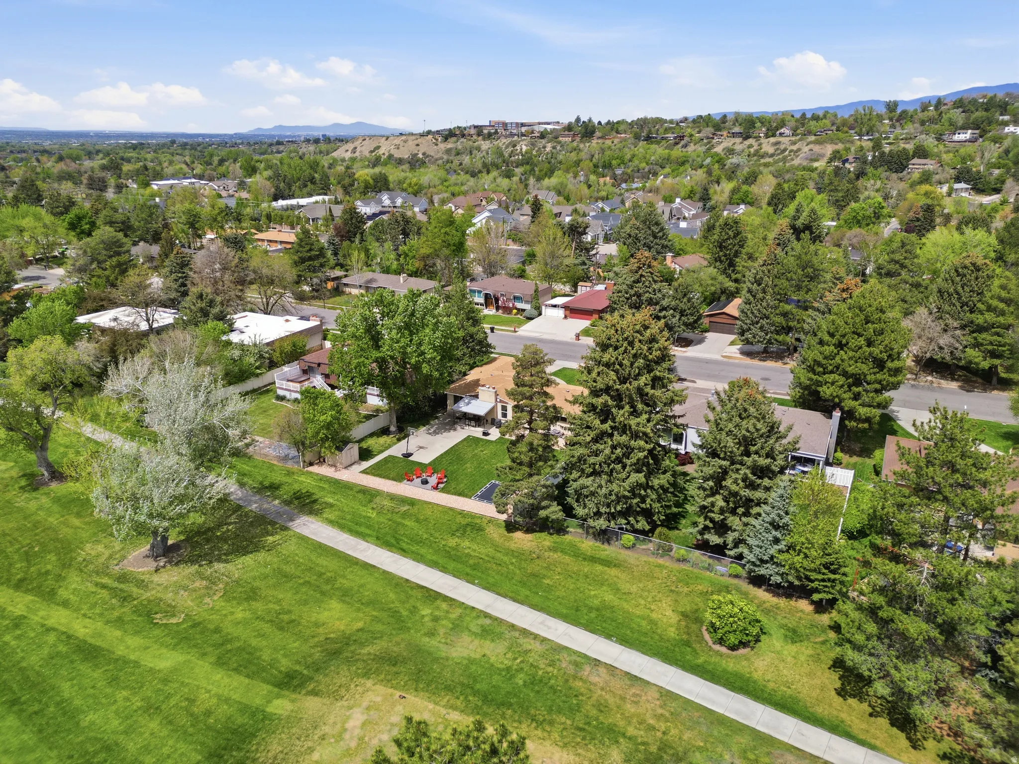Aerial perspective of suburban area with a golf course and mountain backdrop