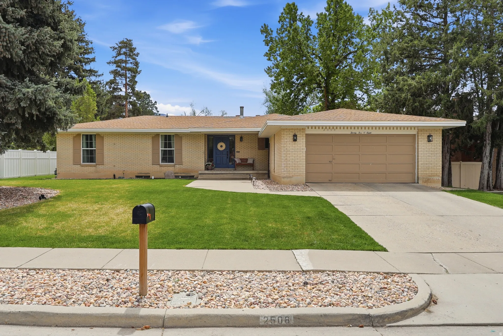Ranch-style home featuring a garage, driveway, and brick siding