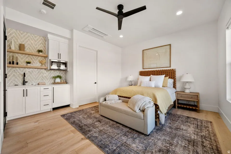 Bedroom featuring light wood-style flooring, a ceiling fan, wet bar, and recessed lighting