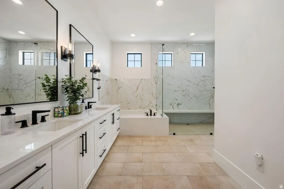Full bath with double vanity, a garden tub, a marble finish shower, recessed lighting, and light tile patterned floors