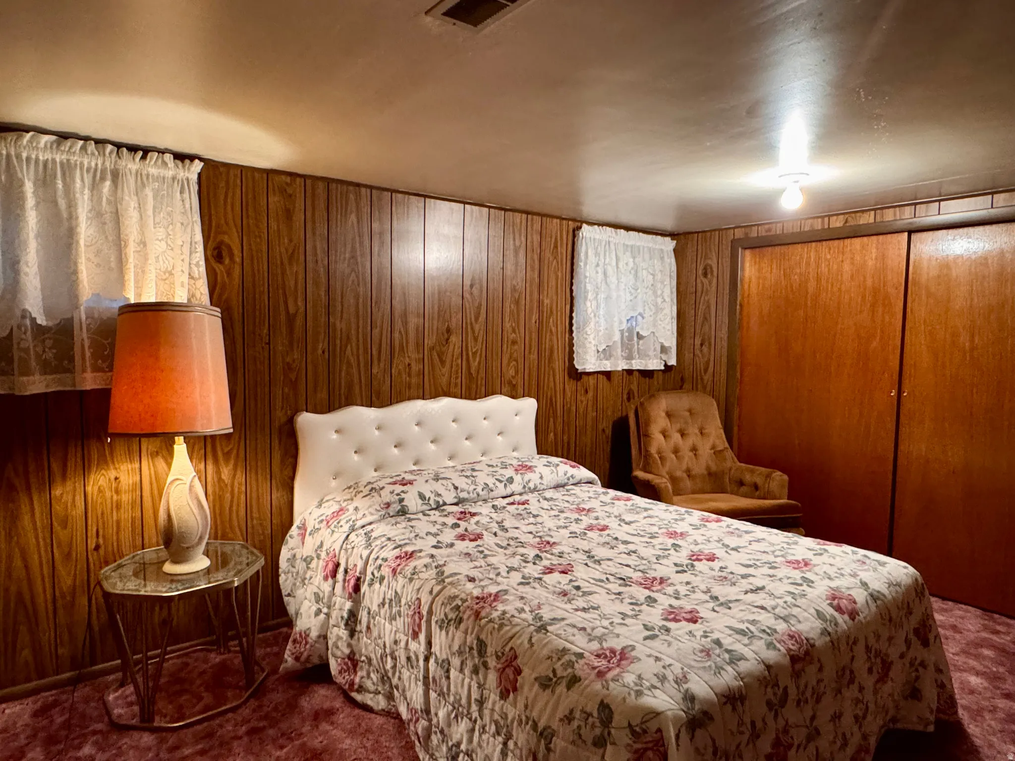 Bedroom with wooden walls and carpet floors