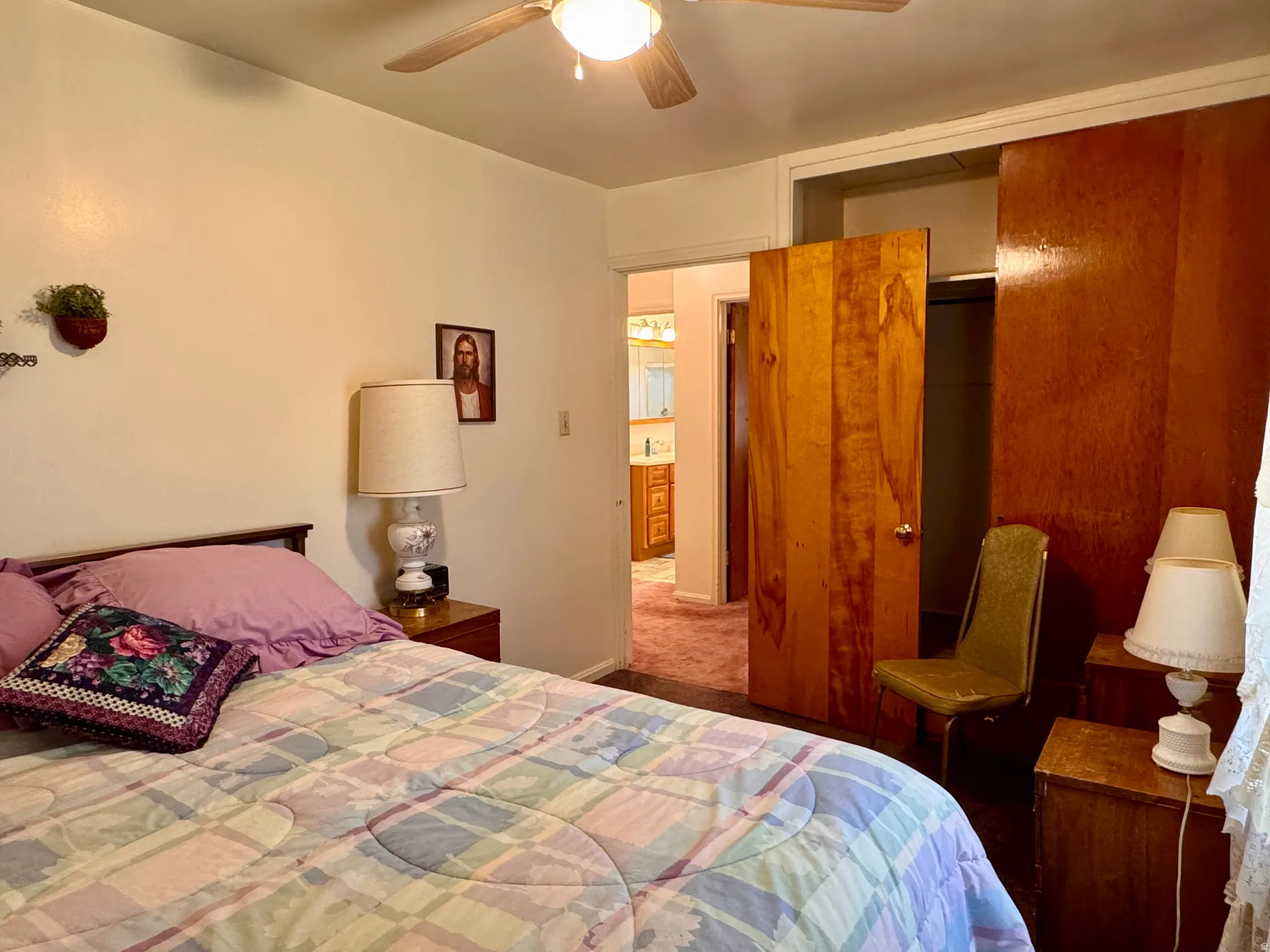 Carpeted bedroom featuring a closet and a ceiling fan