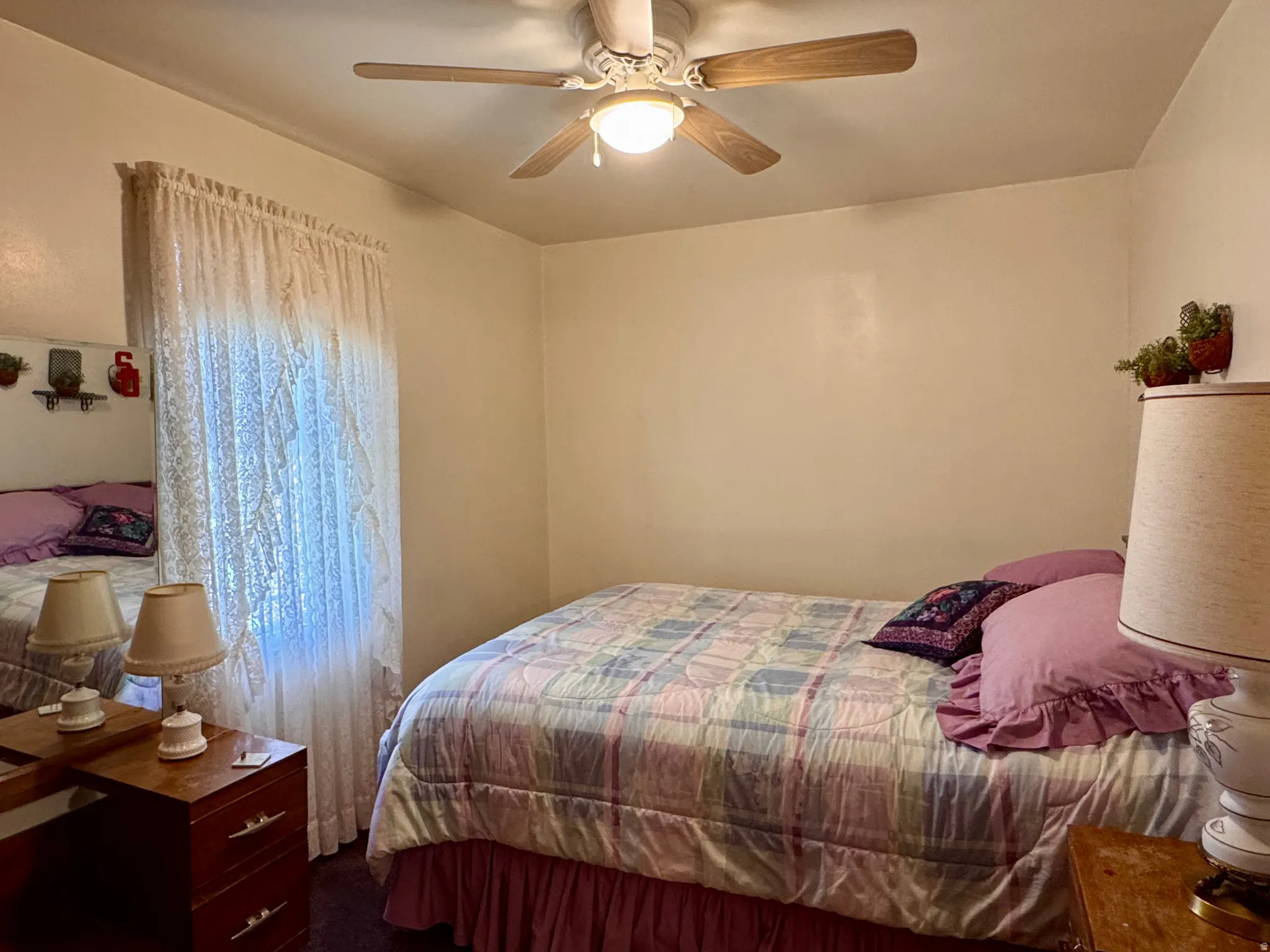Bedroom with ceiling fan and dark carpet