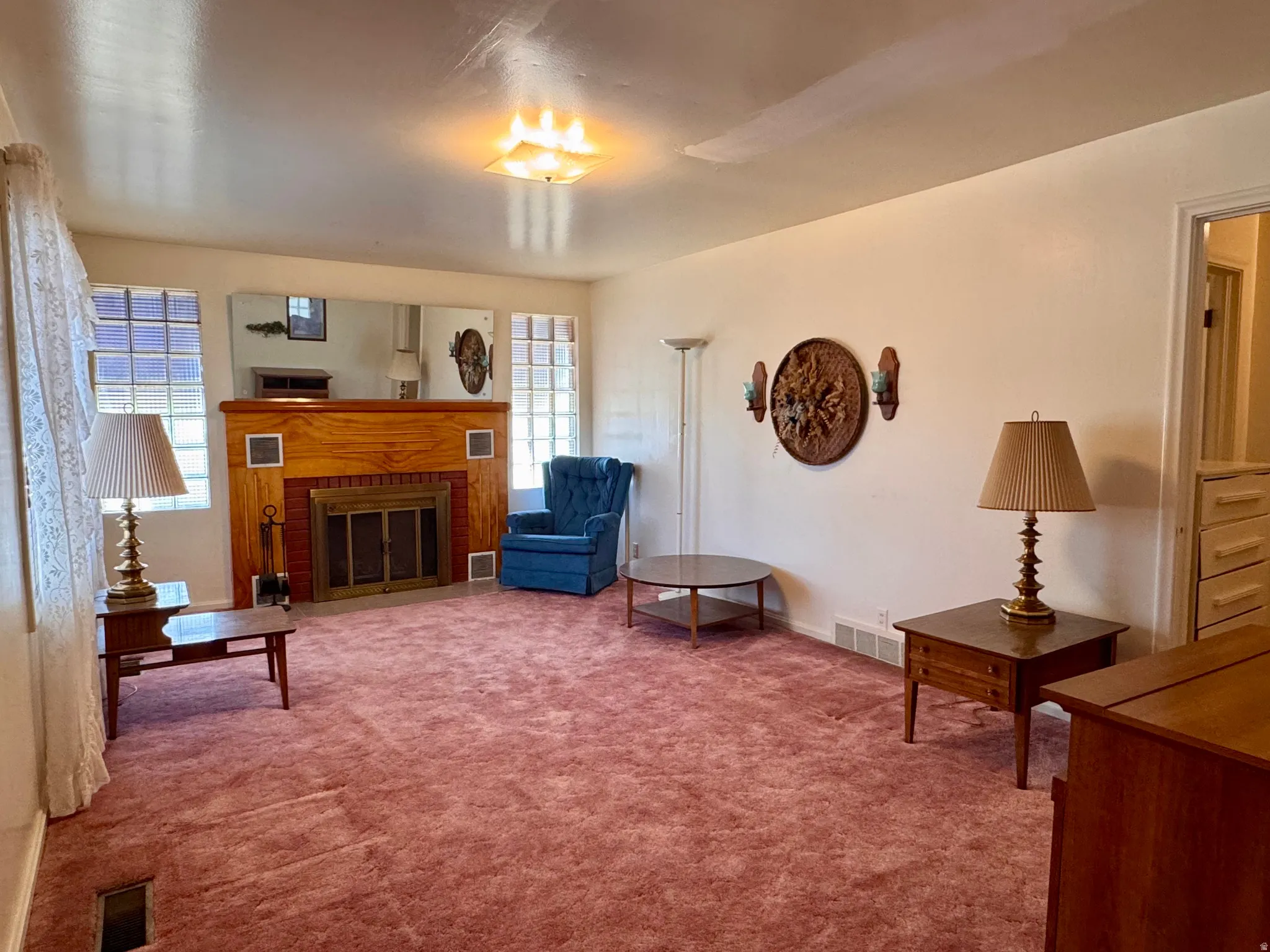 Living room with light colored carpet and a brick fireplace