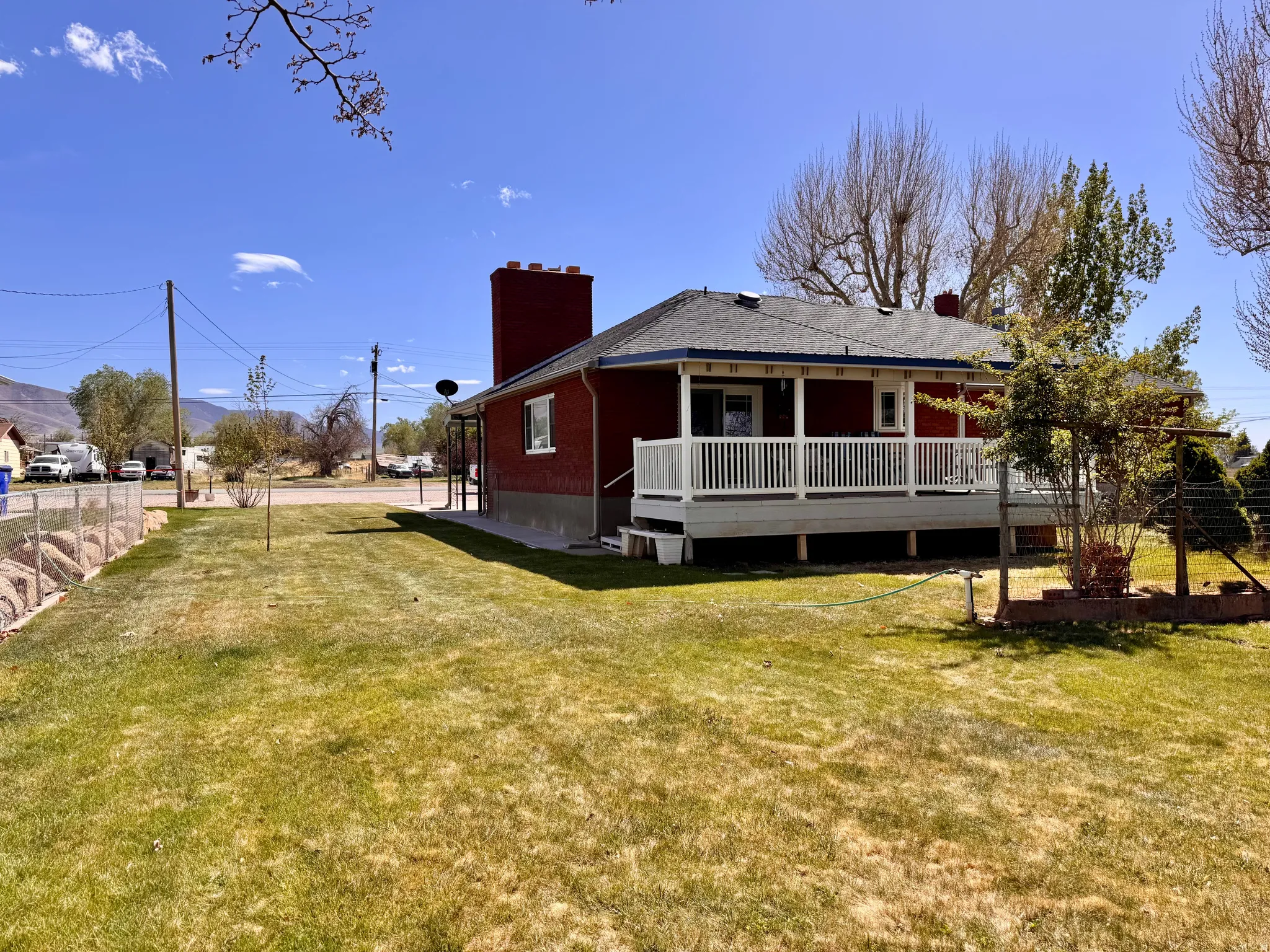 Rear view of property featuring a chimney, a deck with mountain view, and roof with shingles