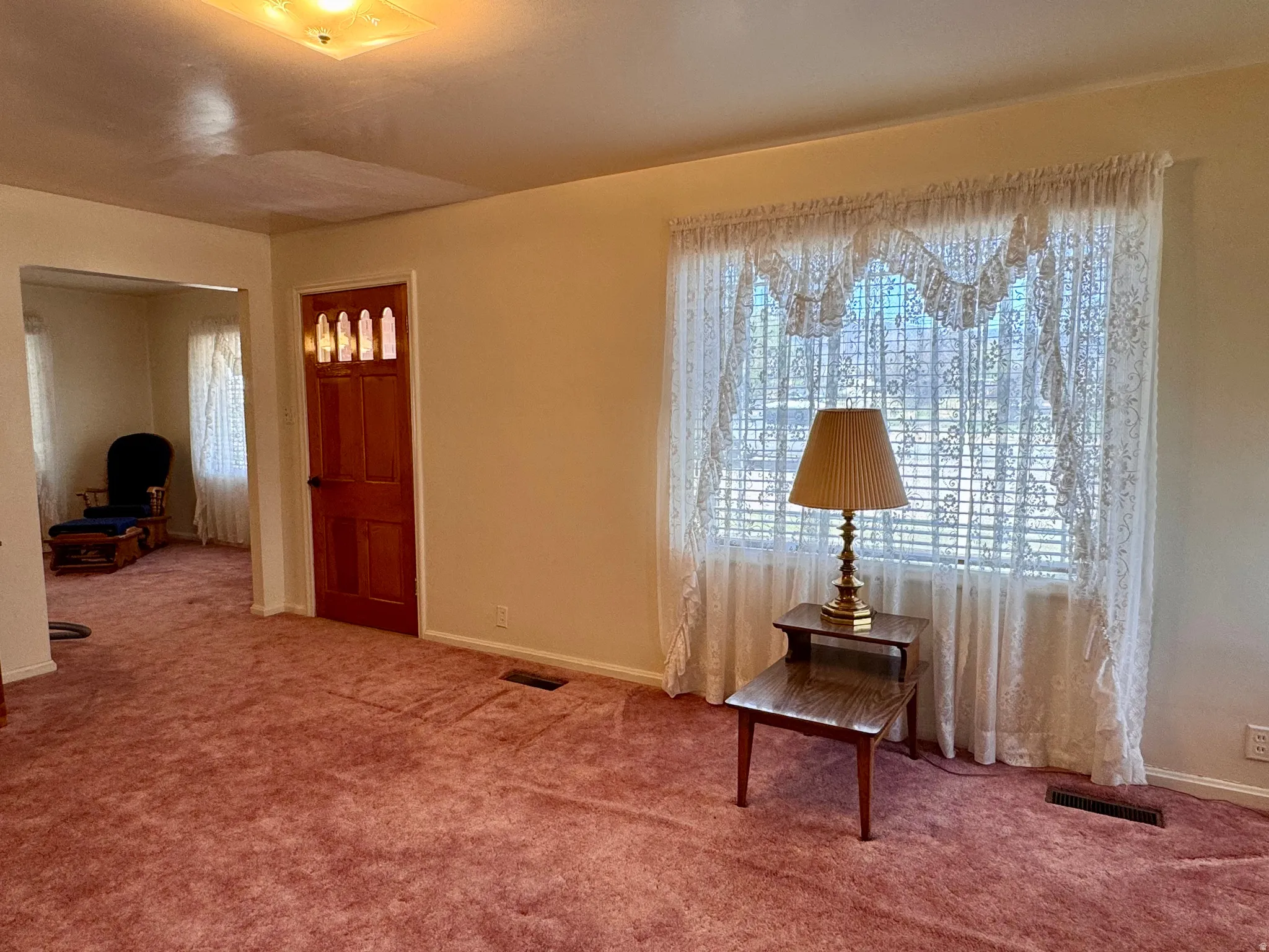 Carpeted foyer entrance with baseboards