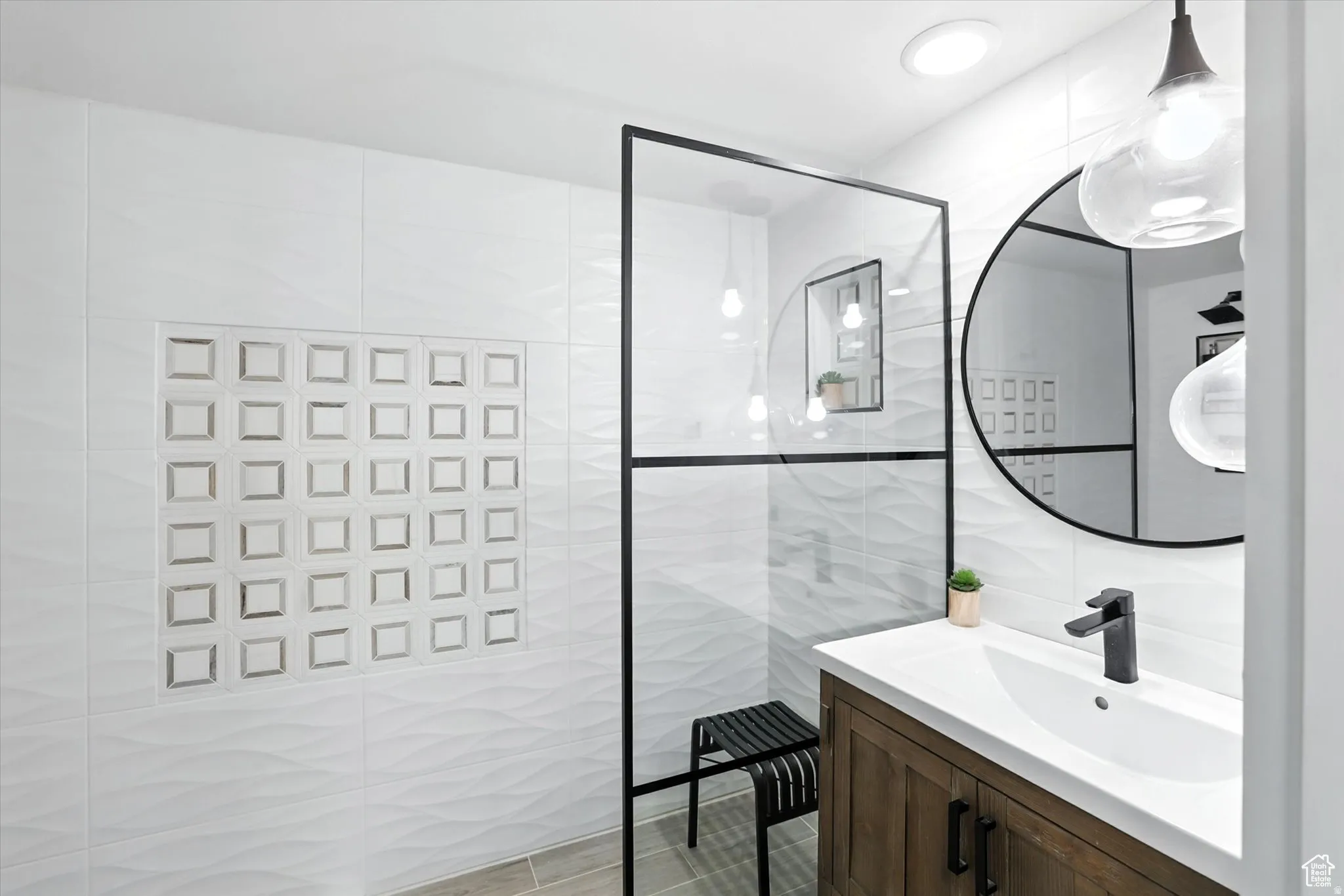 Bathroom suite with tile walls, vanity, and a walk in shower