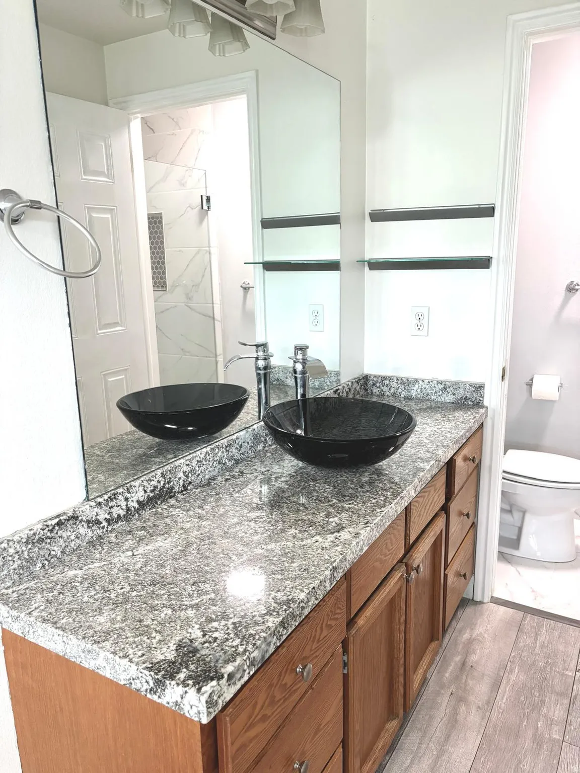 Bathroom with vanity, light wood-style floors, and a marble finish shower