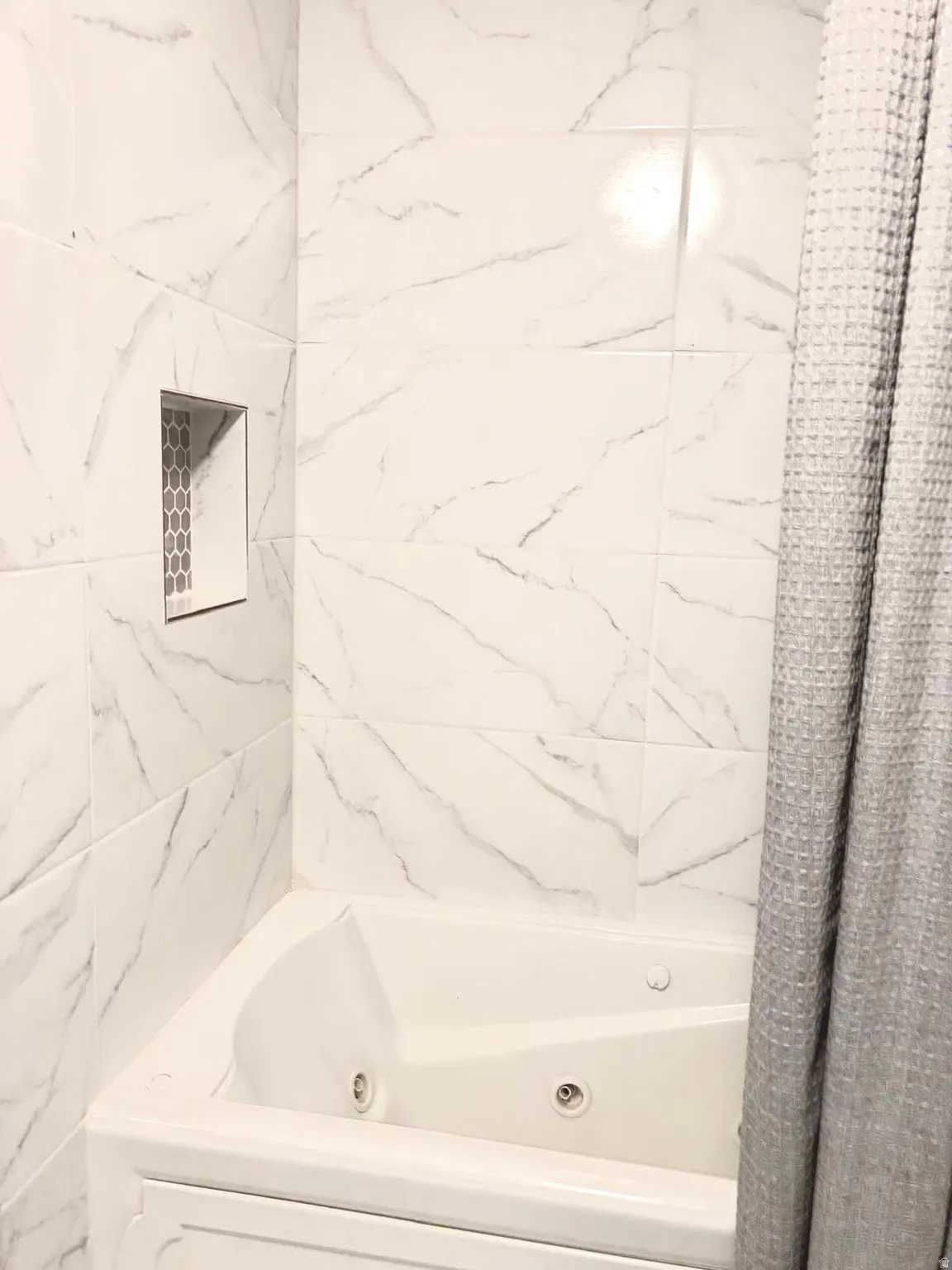 Bathroom with a combined bath / shower with jetted tub