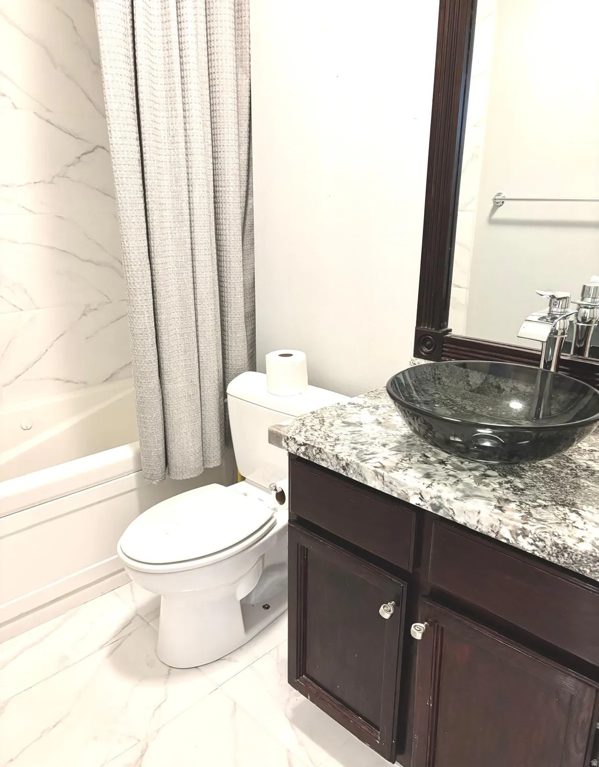 Bathroom with vanity, light marble finish flooring, and shower / tub combo with curtain