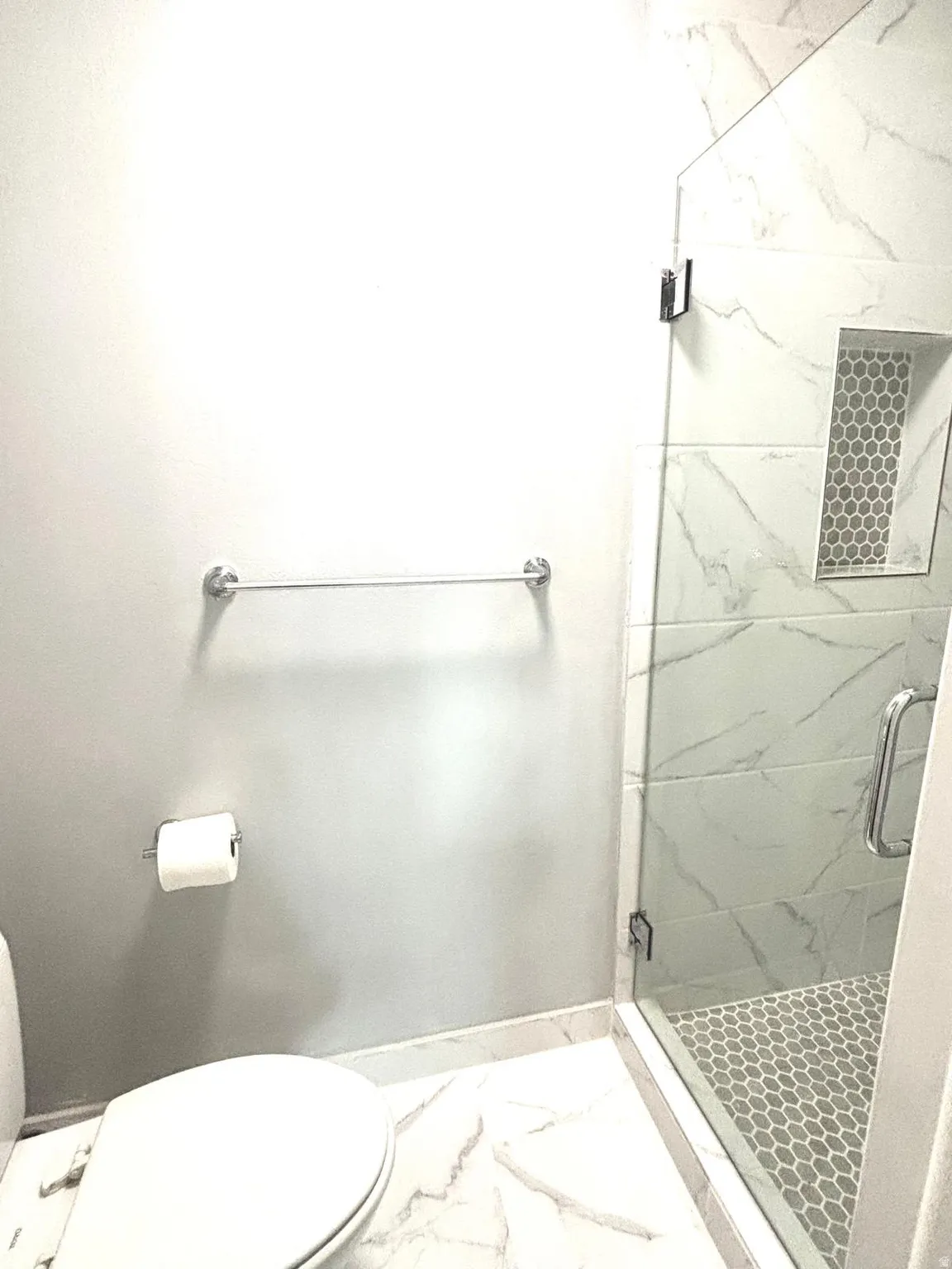Bathroom featuring a marble finish shower and light marble finish flooring