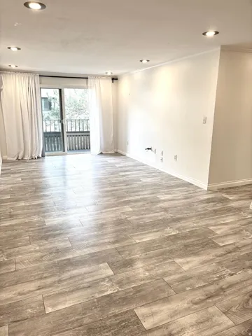 Empty room with wood finished floors, recessed lighting, and crown molding