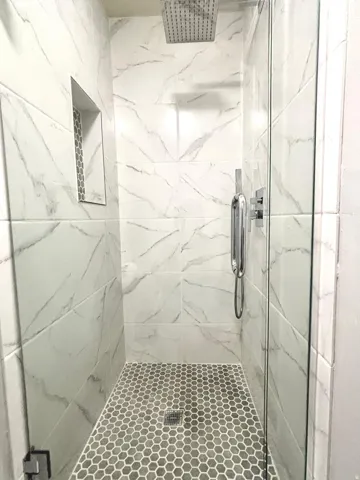 Bathroom featuring a marble finish shower
