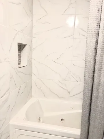 Bathroom with a combined bath / shower with jetted tub