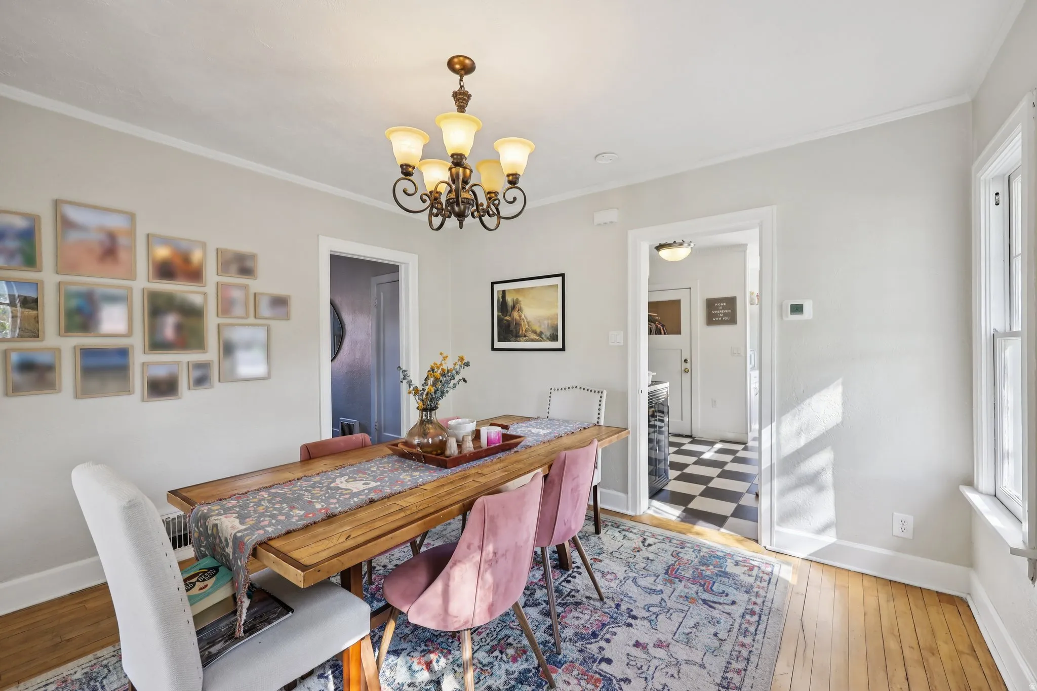 Dining room featuring suspended lighting, light wood-style flooring, and crown molding