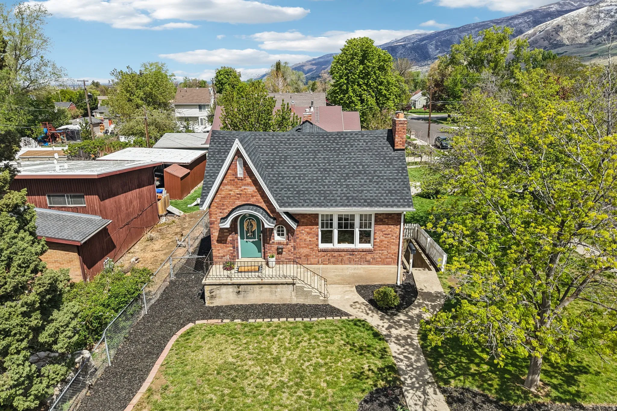 View of front of home featuring brick siding, a chimney, roof with shingles, and a mountain view