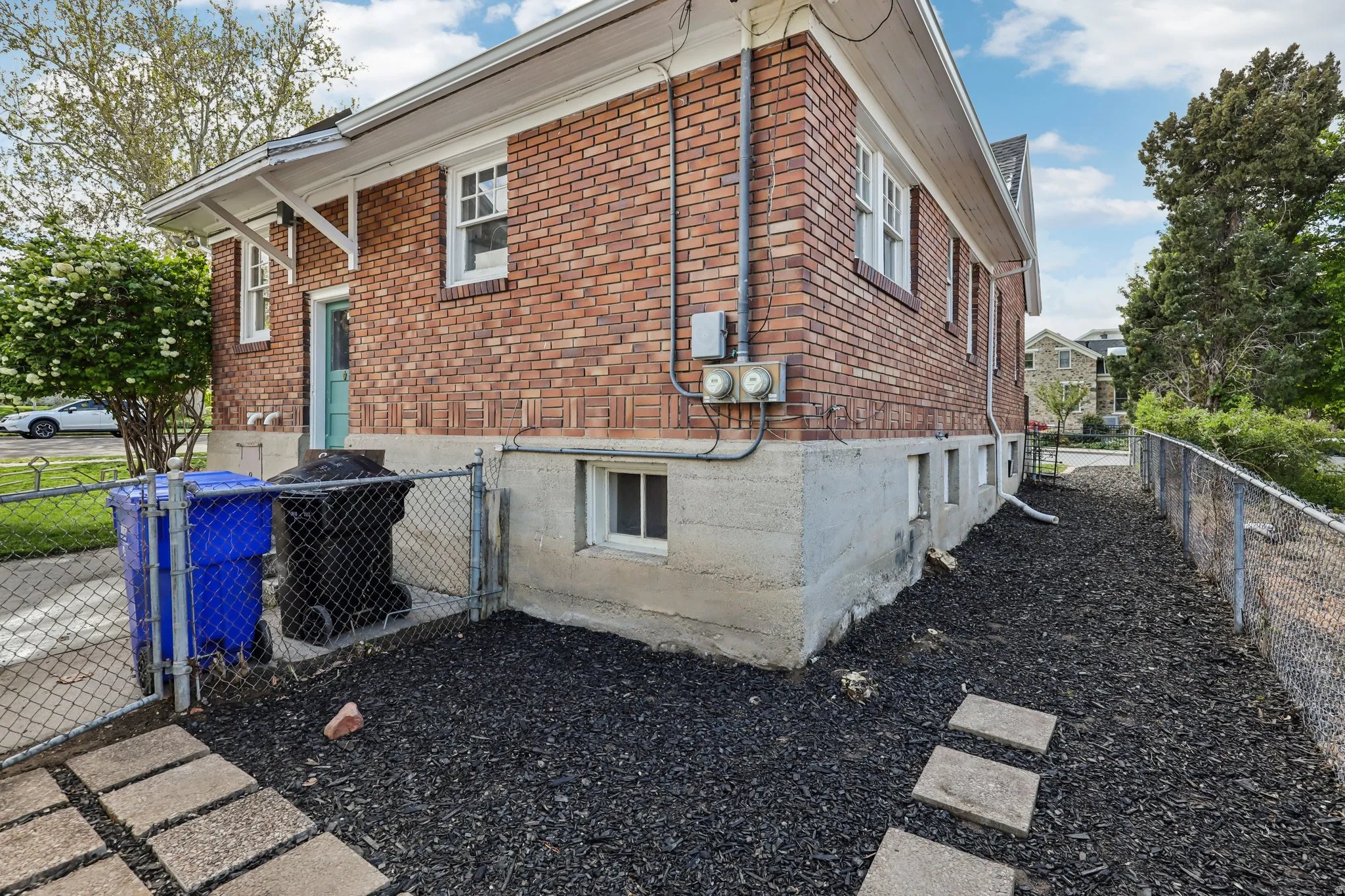 View of home's exterior featuring brick siding and a gate