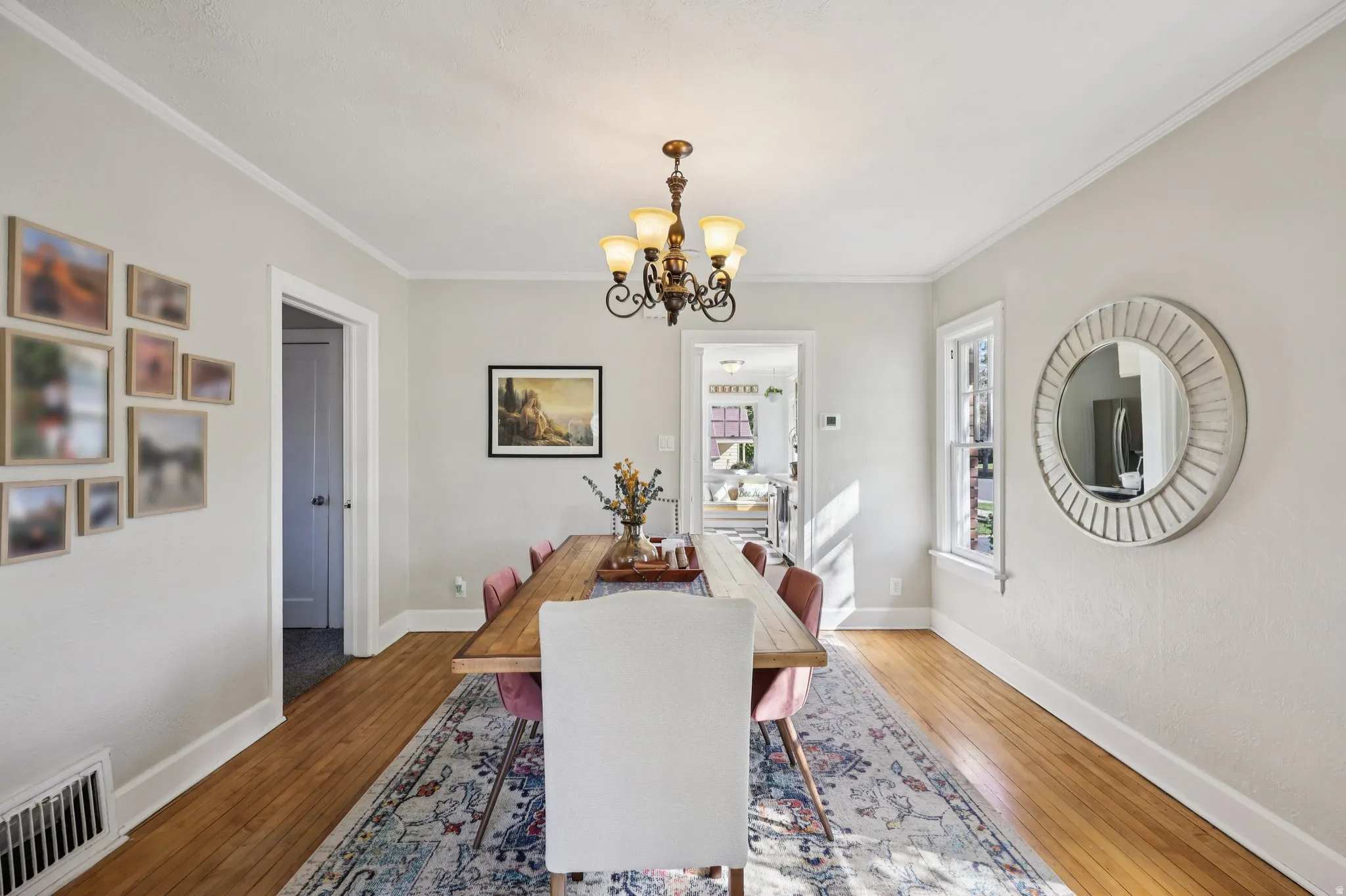Dining space with hanging lights, hardwood / wood-style flooring, and ornamental molding