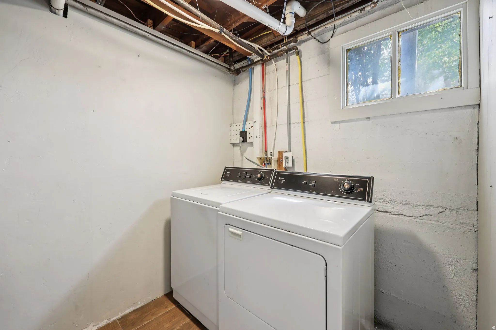 Laundry area featuring washer and clothes dryer and dark wood-style flooring