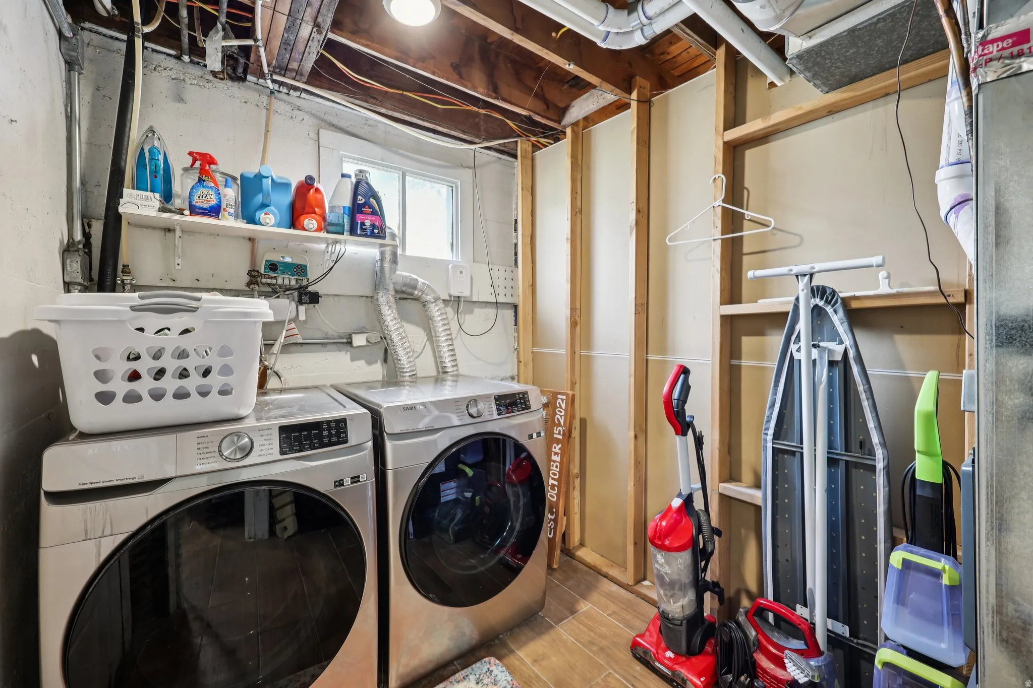 Laundry area with independent washer and dryer and wood tiled floors