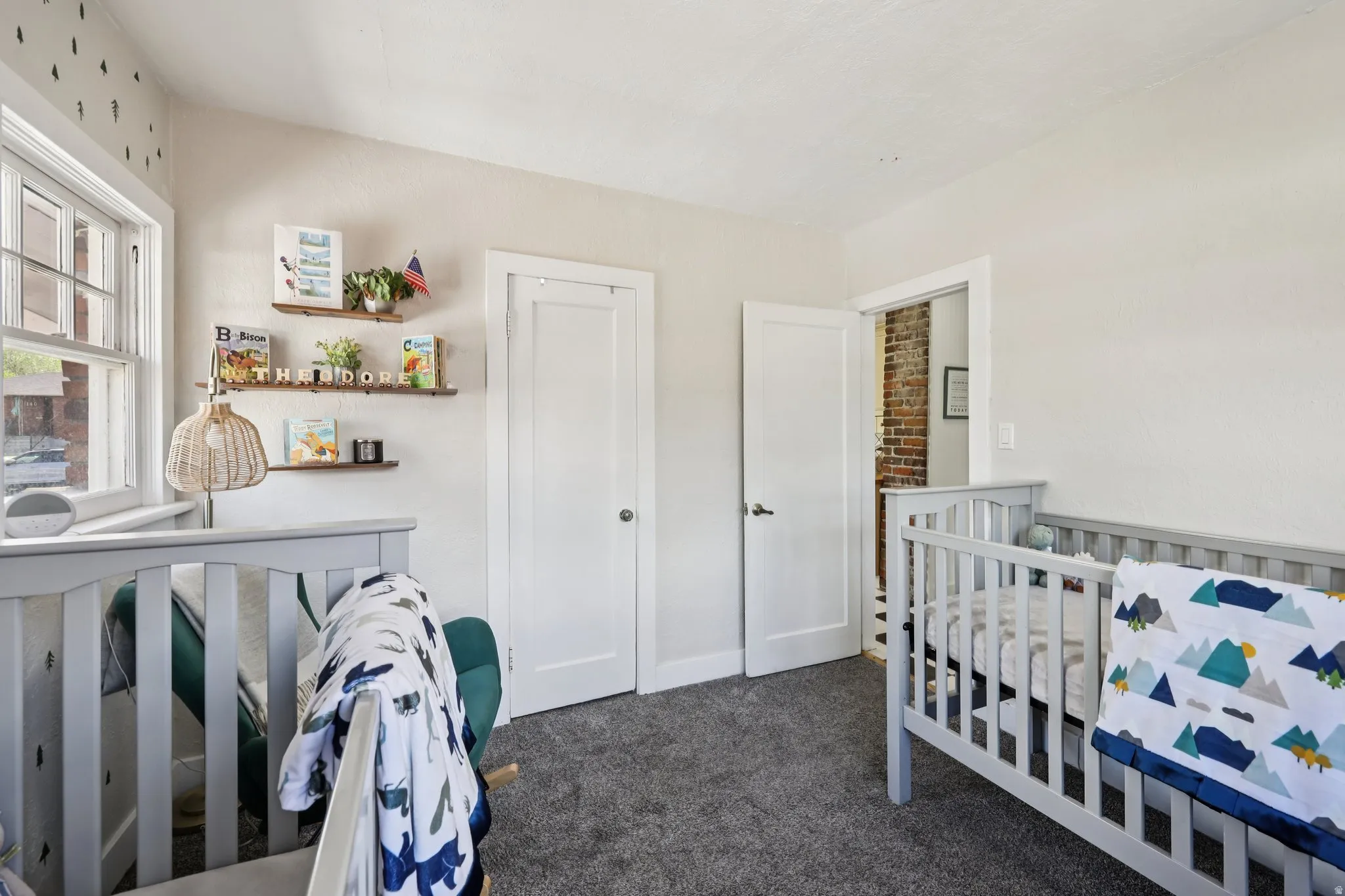 Bedroom featuring dark carpet and a nursery area