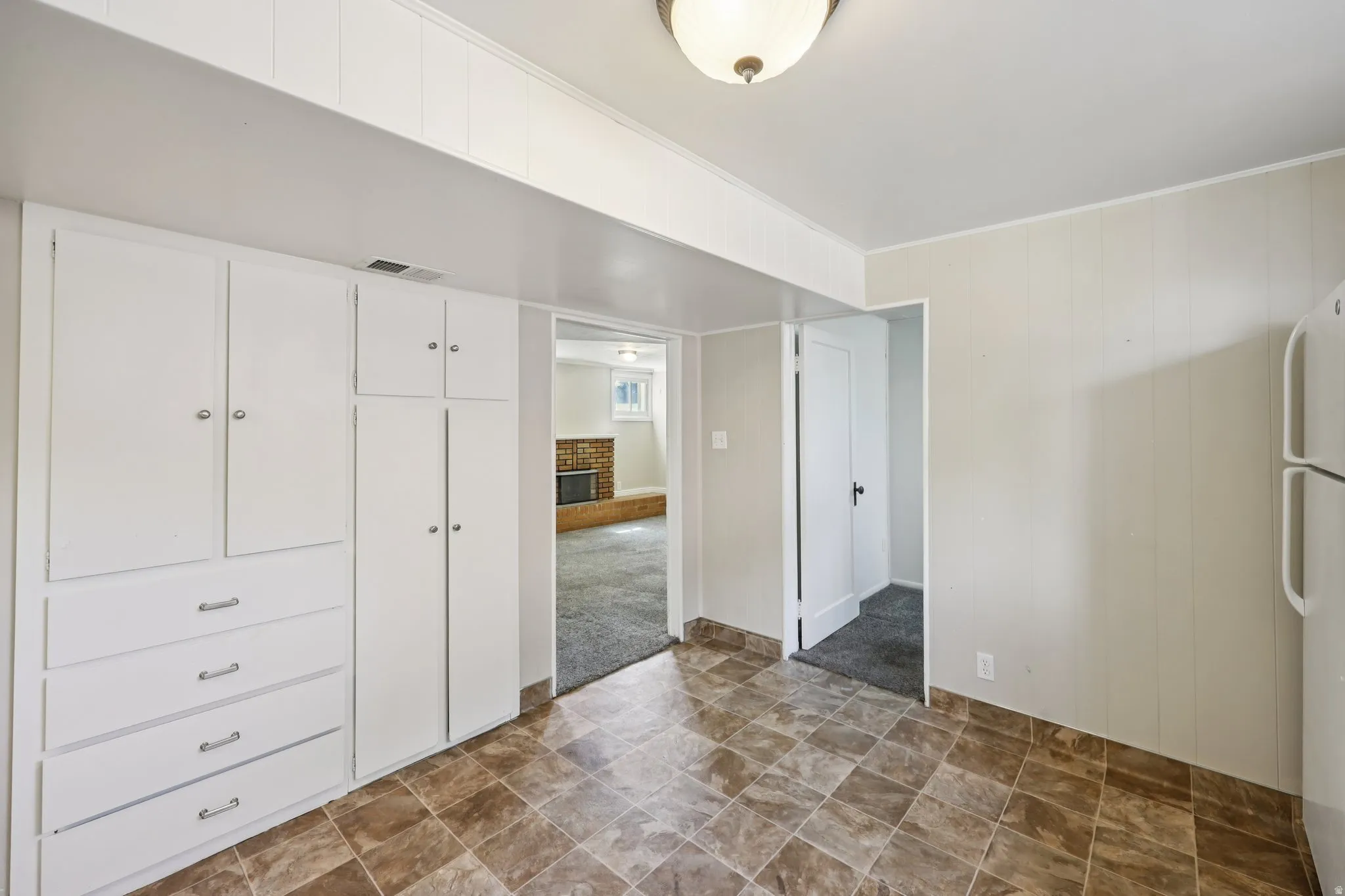 Interior space with stone finish flooring, a fireplace, and ornamental molding